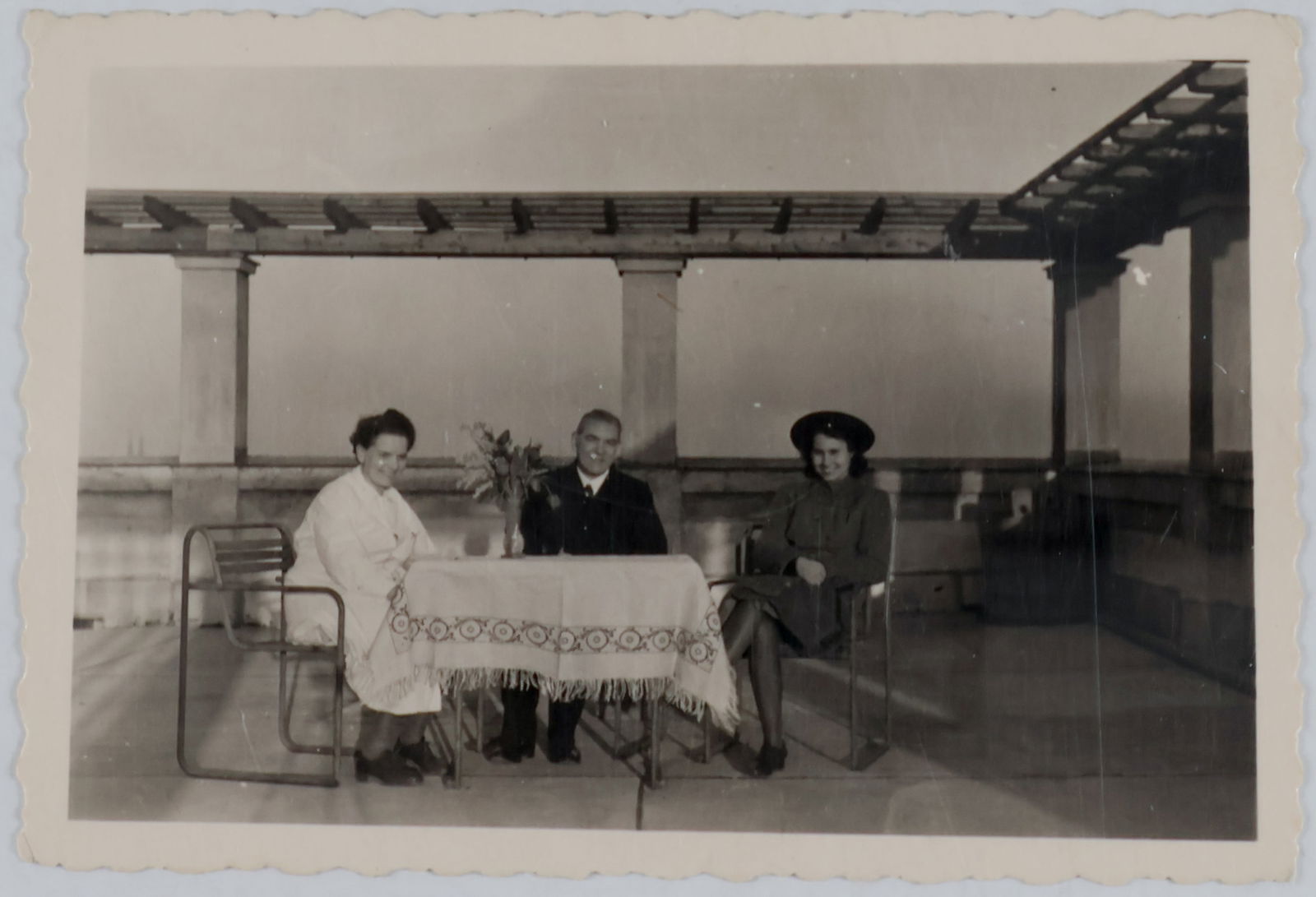 (ANGELA HITLER): A fine vintage photograph 3.5 x 2.25 in. b/w, an unpublished, private image from the estate of Angela Hitler, depicting three individuals seated at a table at Hitler’s home in Obersalzburg. We