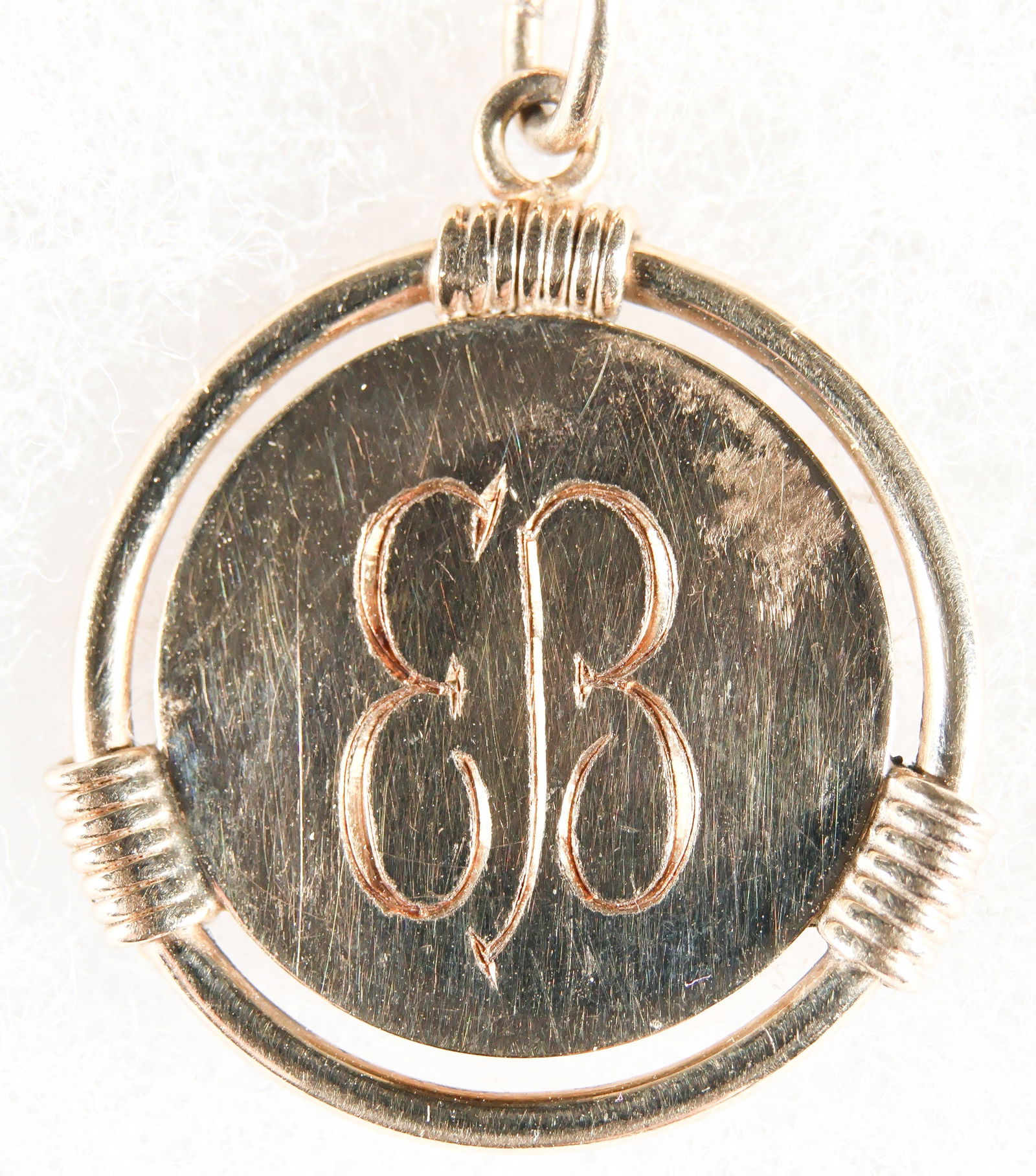 EVA BRAUN'S GOLD PENDANT: A small gold circular pendant once owned and worn by Hitler's mistress, Eva Braun, about 1/2 in. diameter with open-framed perimeter and a ring attachment for a chain and a recently added chain,