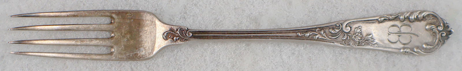 EVA BRAUN SILVER DINNER FORK: An informal sterling silver dinner fork once owned by Adolf's Hitler's wife, Eva Braun. The ornate 7.5 in. four tine fork has an attractive floral and filigree design, along with Braun's