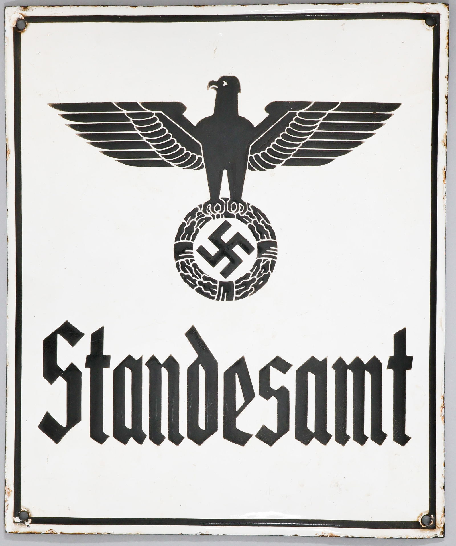 'STANDESAMT' ENAMELED SIGN: Original enameled sign from the Third Reich era, 9.75 x 11.75 in. convex iron sign with raised black printing 'Standestamt' beneath the image of a national eagle with swastika. Clearly this sign was