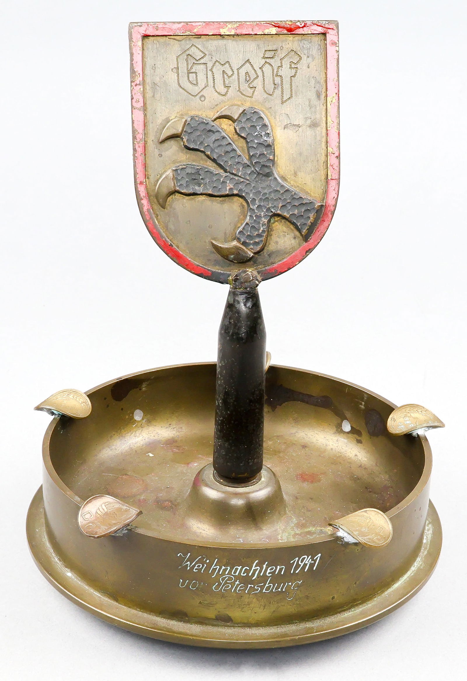 GERMAN 122ND INFANTRY DIVISION TRENCH ART: A great piece of trench art from the German 122nd Infantry 'Greif' Division. The cleverly constructed piece is comprised of the bottom portion of a 7 in. diameter shell casing resting on four small