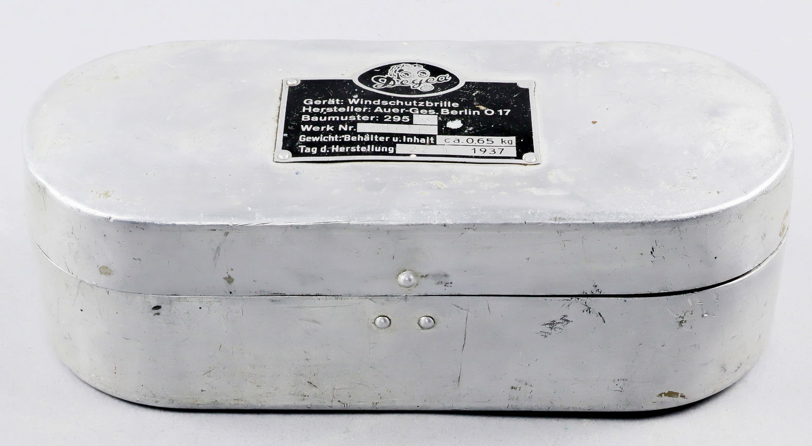 LUFTWAFFE FLIGHT GOGGLES ALUMINUM CASE: Luftwaffe Wind Protection Flight Goggles Case (Behalter für Windschutzbrille). The oval aluminum case with fold over top lid was once used to store the Model 295 wind protection flight goggles,