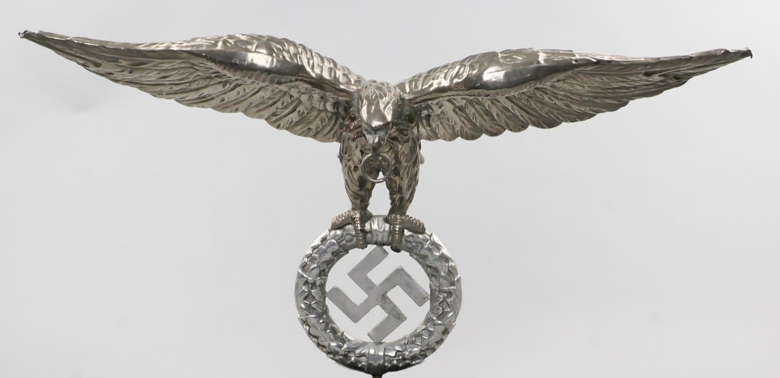 THIRD REICH SCHELLENBAUM EAGLE: A very rare Nazi schellenbaum eagle, 21.75 in. wide x 12 in. high, a magnificent eagle with ring clenched in its beak, outspread wings, and talons clutching a large oak leaf wreath, with swastika. The