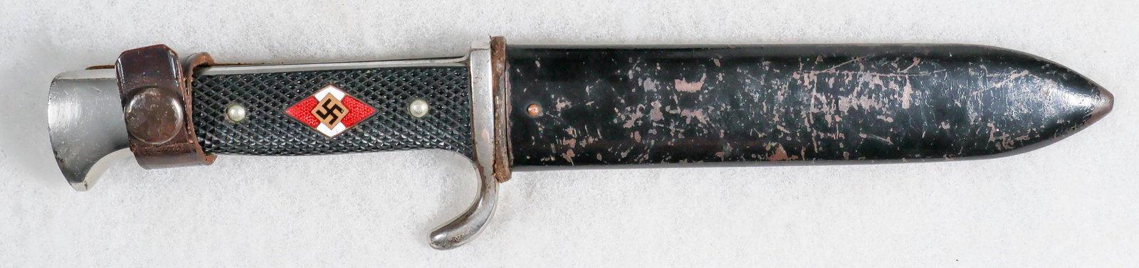 HITLER YOUTH KNIFE WITH MOTTO: A good, early example of a Hitler Youth knife, 5.5 in. blade, etched ‘Blut und Ehre!’. Checkered black grip inset with enameled Hitler Youth emblem, which is tight within the grip and free of chip