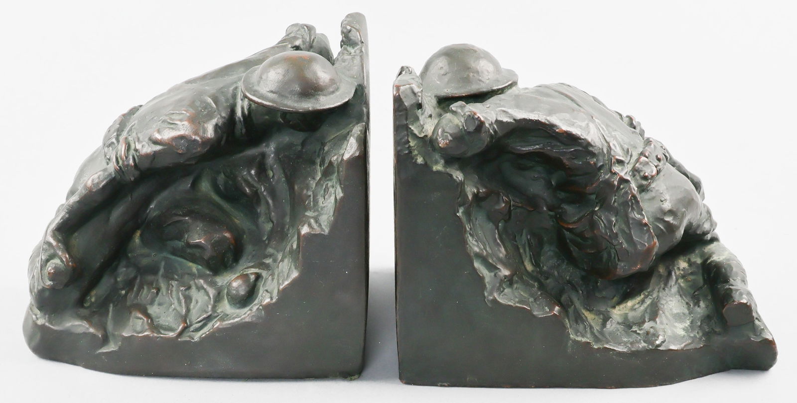 BRITISH SOLDIER BRASS BOOKENDS: Pair of impressive matching bookends, each depicting a British soldier kneeling as he prepares to throw a grenade from behind cover with another grenade before his right knee, ready to be deployed. Th