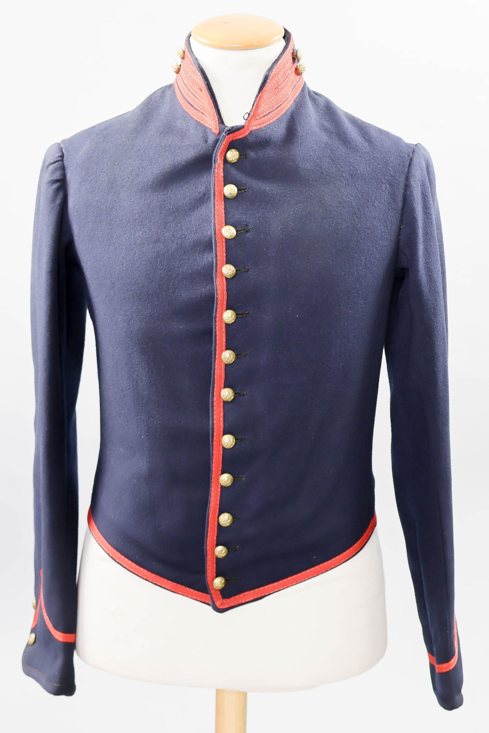 UNION ARTILLERYMAN’S SHELL JACKET: A very attractive Union artilleryman’s uniform jacket, constructed of heavy, indigo blue-dyed wool, and decorated with worsted herringbone piping and features four rows of piping at the front