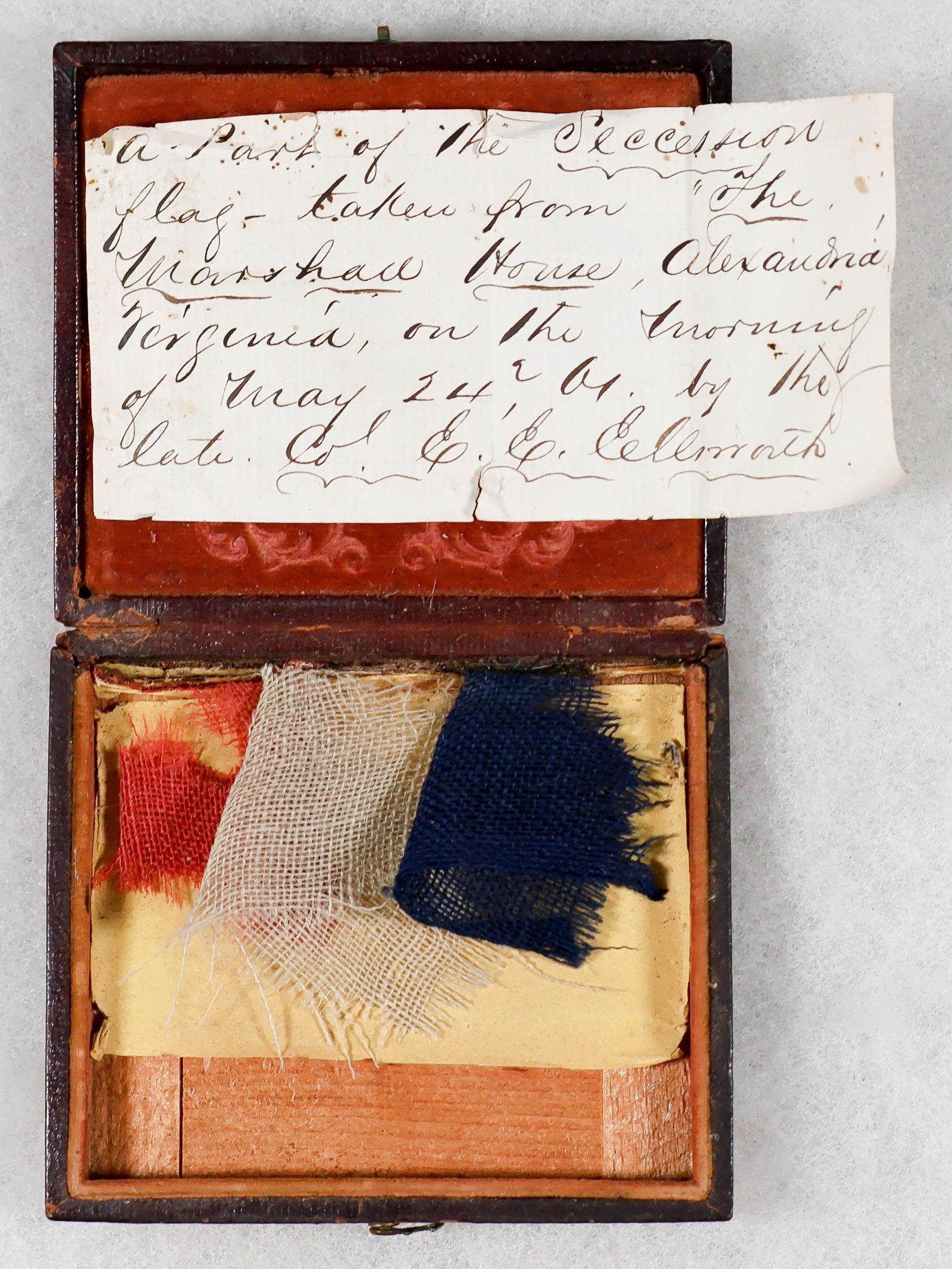 COL. ELMER E. ELLSWORTH FLAG RELICS FROM THE MARSHALL HOUSE HOTEL, WITH A SOLDIER'S LETTER (3): A most stirring relic from the opening days of the Civil War, one piece each of red, white and blue cotton cloth cut from the famous Confederate flag flown from the roof of the Marshall House Hotel in