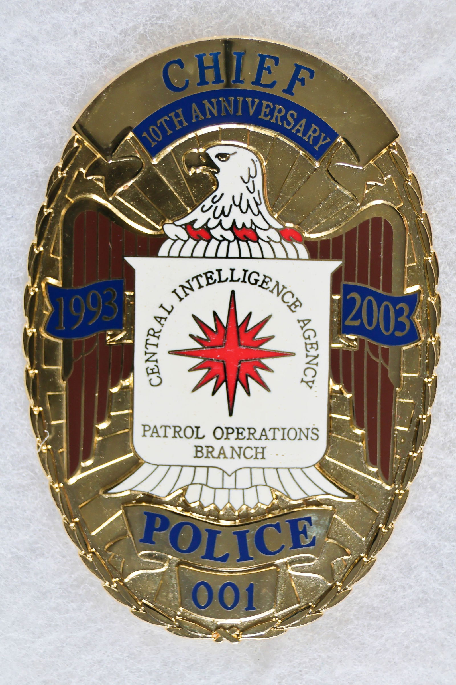 C.I.A. CHIEF OF POLICE ANNIVERSARY BADGE: A unique piece, a large badge presented to the C.I.A. chief of police upon the tenth anniversary of the founding of the Patrol Operations Branch. The gold-plated 3 3/8 in. tall badge is very nicely