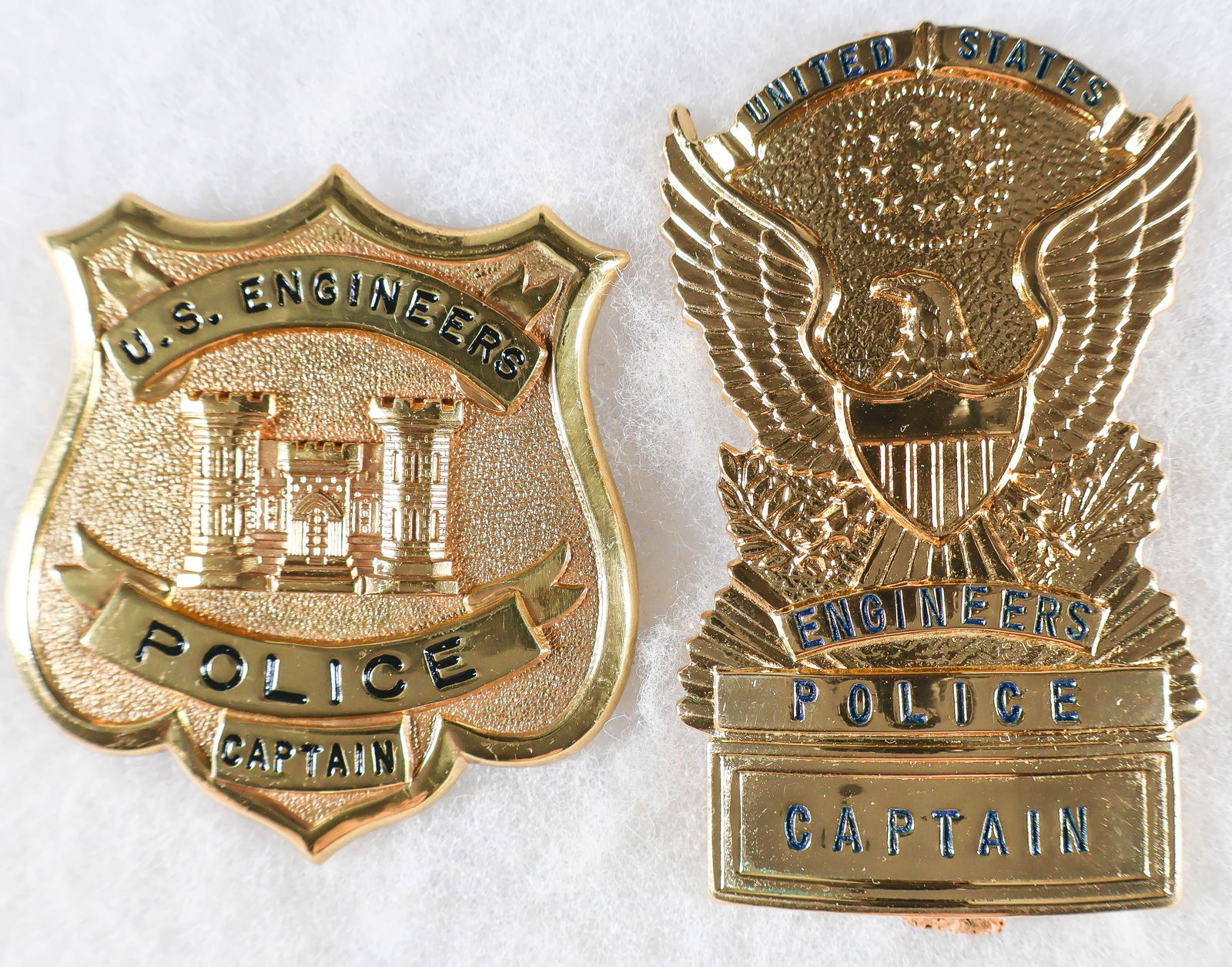U.S. CORPS OF ENGINEERS POLICE CAPTAIN'S BADGE SET (2): Rare pair of U.S. Corps of Engineers Police Captains' badges, both stamped and gold-plated. The first is 3 in. tall with a large spread winged eagle and black lettering in relief: 'UNITED STATES