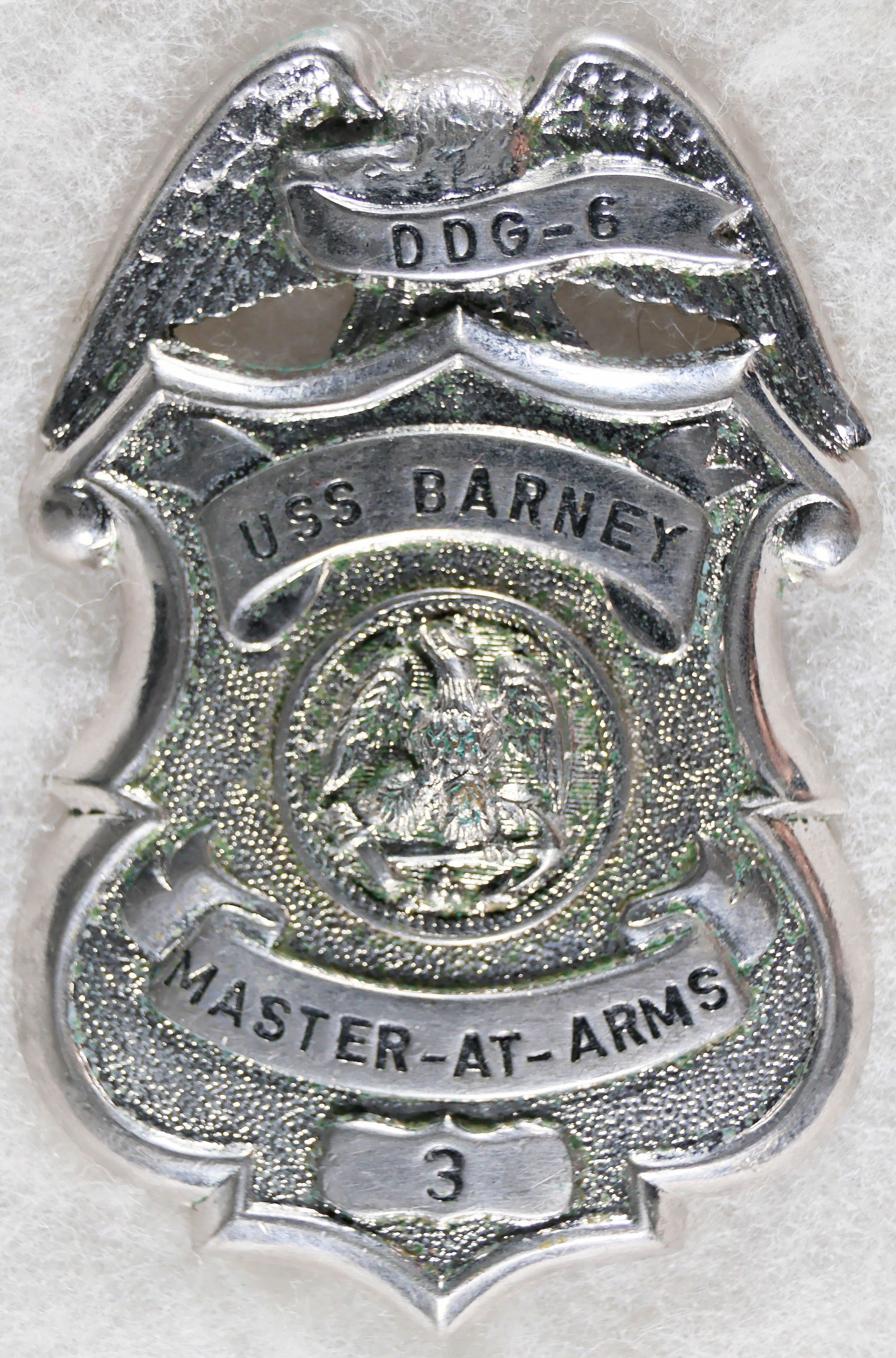 U.S.S. BARNEY MASTER AT ARMS BADGE: USS BARNEY DDG-6 Master-At-Arms shield type badge, 3.25 in. tall, displays an eagle at top with banner with lettering in relief: 'DDG-6'. Beneath appears an eagle with fouled anchor, symbolic of the