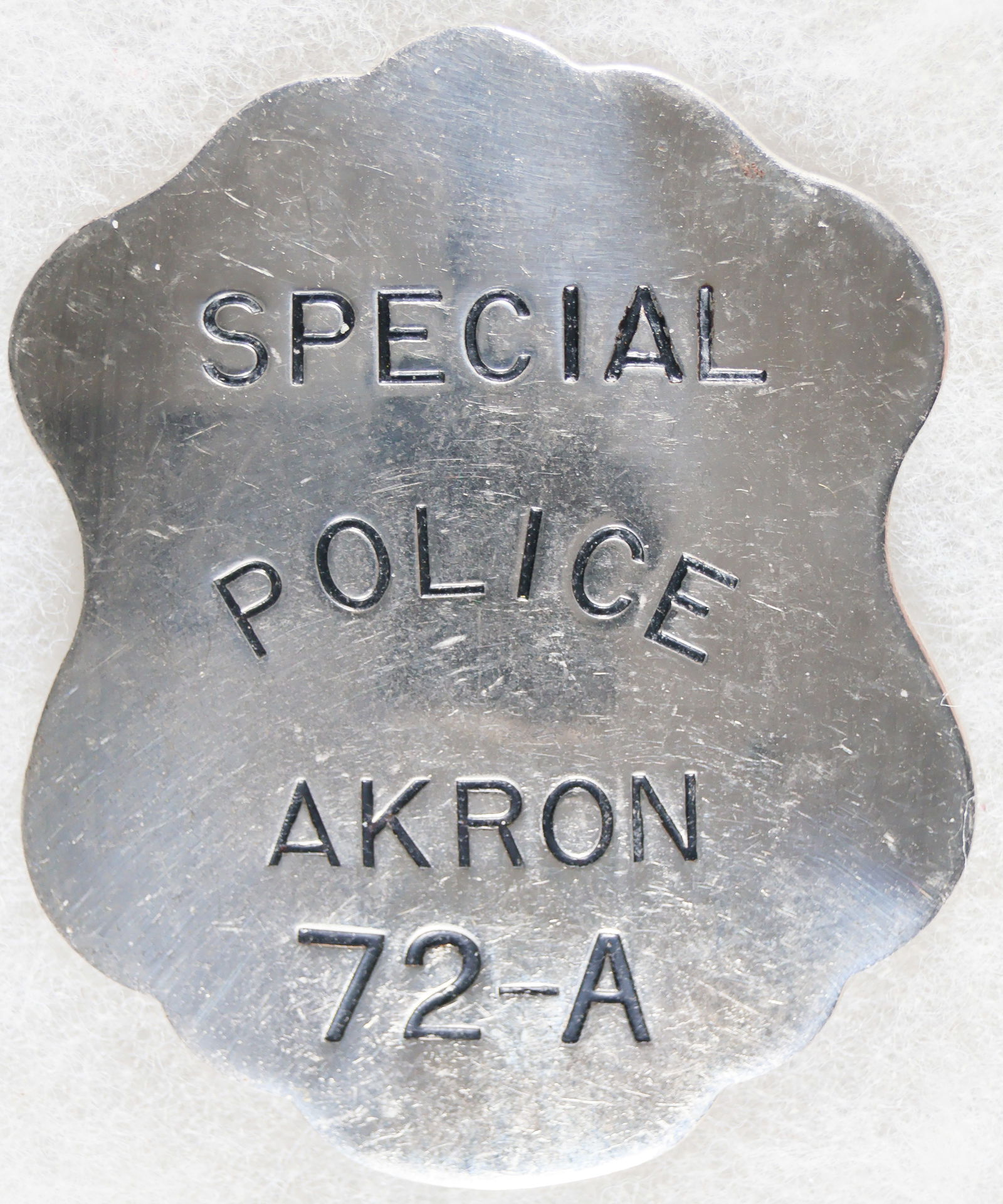 AKRON SPECIAL POLICE BADGE: Unusual shield-shaped steel badge, 2.75 in. tall, bearing black painted letters in relief: 'SPECIAL POLICE AKRON 72-A'. No maker mark, with a straight vertical pin on the reverse. Near fine.