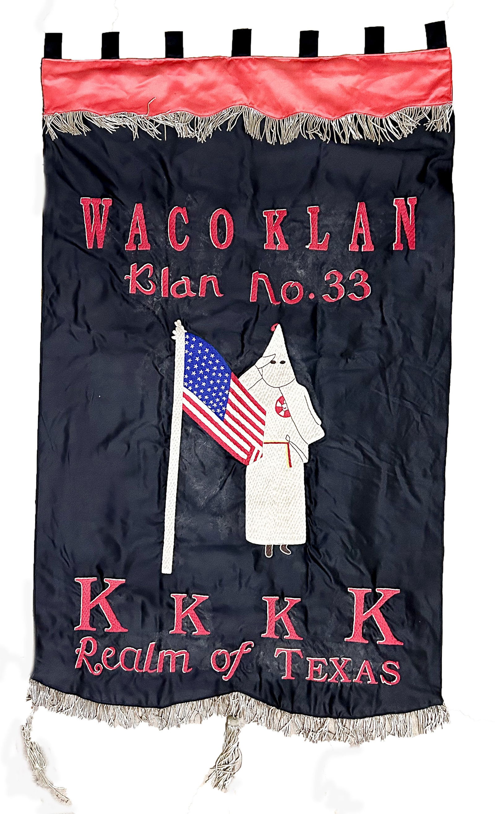 VINTAGE KU KLUX KLAN BANNER: WACO, TEXAS CHAPTER NO. 33: An original, ca. 1920s, black silk/satin banner, three-part construction, approx. 50 x 24 in. with bullion at top and bottom, and a large, embroidered logo and robed Klansman at middle. Fabric loops