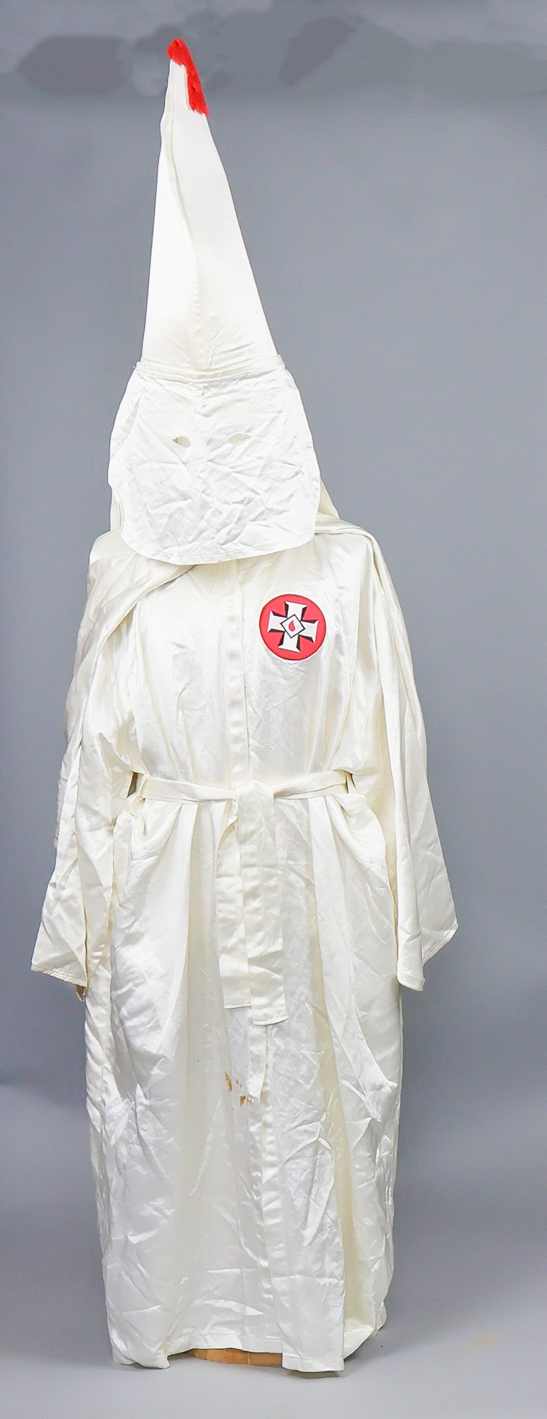 UNITED KLANS OF AMERICA ROBE AND HOOD: Later ca. 1960’s-70’s United Klans of America robe and hood, both constructed of white satin-finish rayon, the robe featuring a nylon ‘Knights of Kamellia’ patch on the left