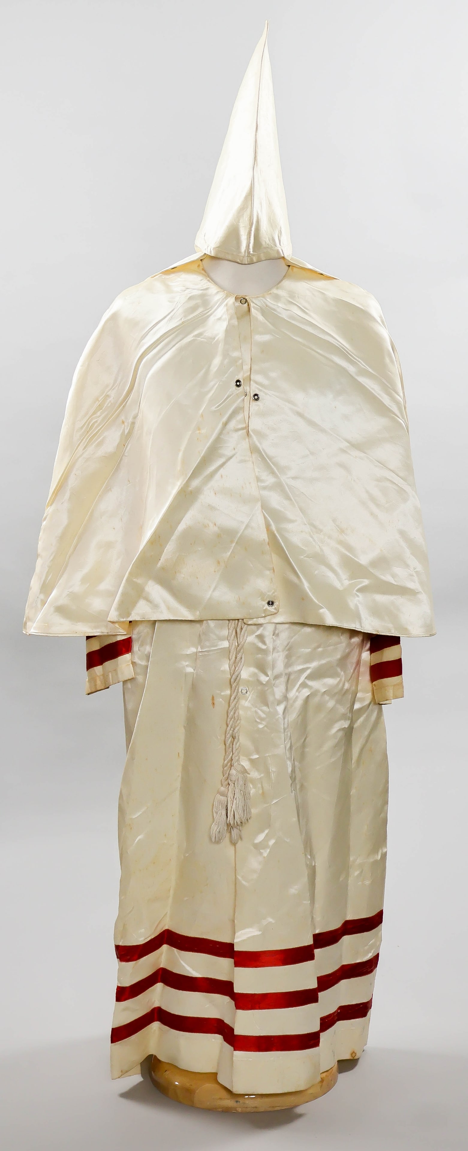 OFFICER’S KU KLUX KLAN ROBE FROM ROBERT E. SCOGGIN BRANCH, SOUTH CAROLINA: A ca. 1960s officer’s robe and hood from the small but notorious South Carolina group headed by Grand Dragon Robert E. Scoggin. This group is notable for its unique use of silk-like robes with