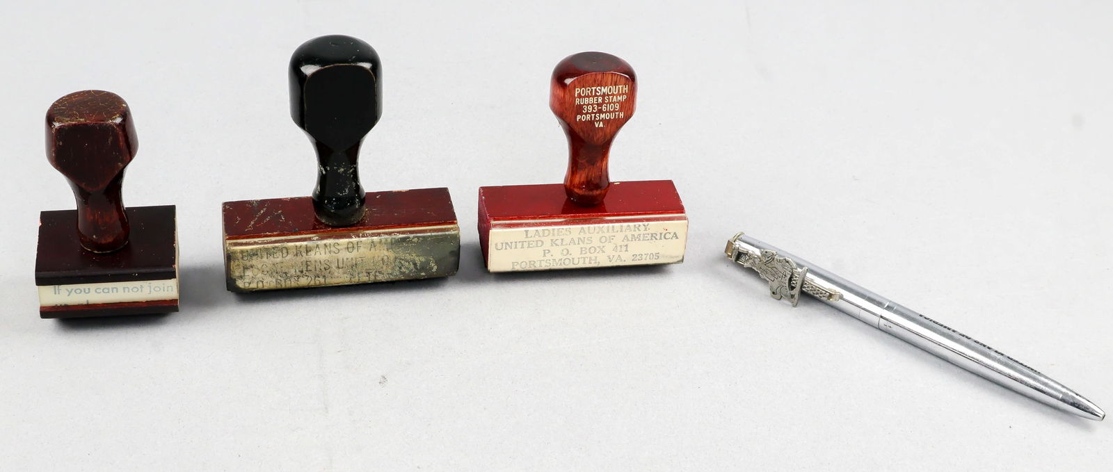 KU KLUX KLANS RUBBER STAMPS AND PEN (4): A group of three rubber stamps, the first 2.33 in. long, bearing the return address of the Ladies Auxiliary in Portsmouth, VA. WITH: a stamp, 2.5 in. long, bearing the return address of the United