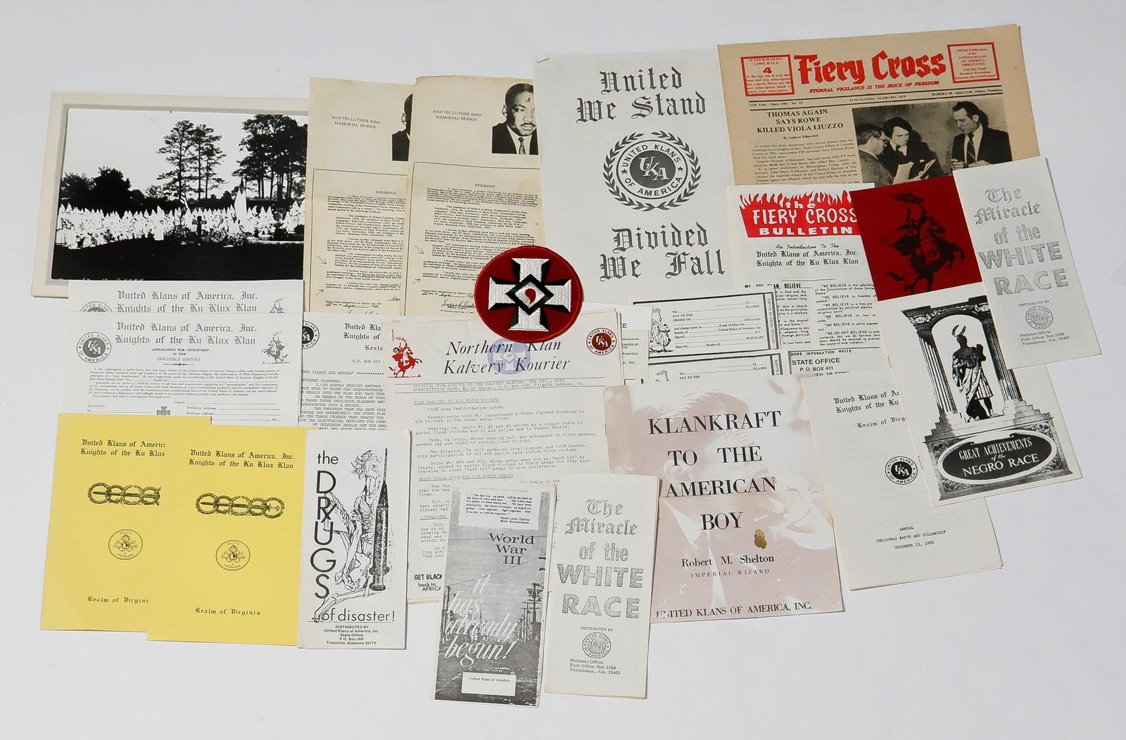 THIRD KLAN DOCUMENT AND PROPAGANDA GROUPING (25+): Significant grouping of Sixties Ku Klux Klan ephemera, also including an unused 4 in. wide Knights of Camelia patch; four menacing 'calling cards'; 1979 'Fiery Cross' newspaper and bulletin; 1983