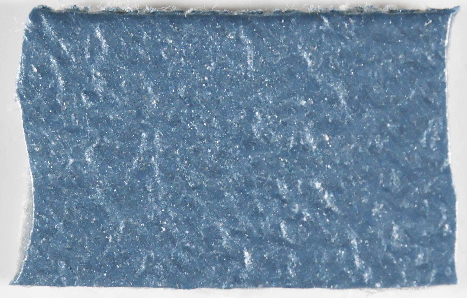 (JOHN K. KENNEDY ASSASSINATION): A chilling relic from the assassination of President John F. Kennedy: a .5 in. x .25 in. piece of the blue leather seat upon which he and First Lady Jacqueline Kennedy sat when Lee Harvey Oswald