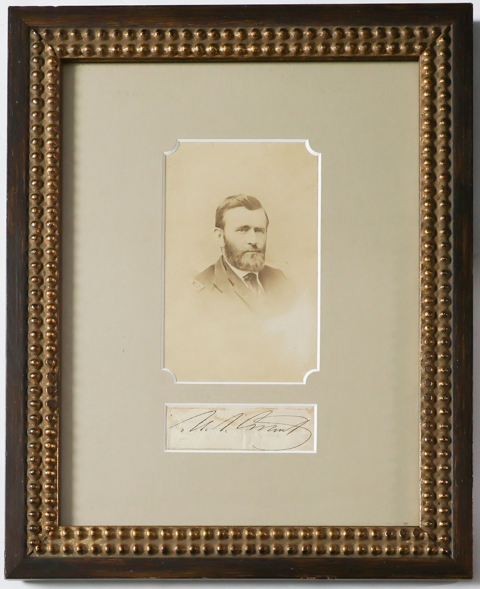 ULYSSES S. GRANT: (1822 - 1885) Eighteenth President of the United States and Union lieutenant general. Signature 'U. S. Grant' on a narrow, lined slip. Some soiling, else very good. Matted with an albumen portrait,
