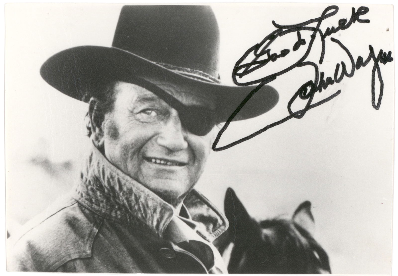 JOHN WAYNE: (1907 - 1979) American film star, 'The Duke' embodied the all-American hero in dozens of westerns and battle pictures. Matte finish 5 x 7 in. b/w photo of Wayne in his Oscar-winning role as 'Rooster