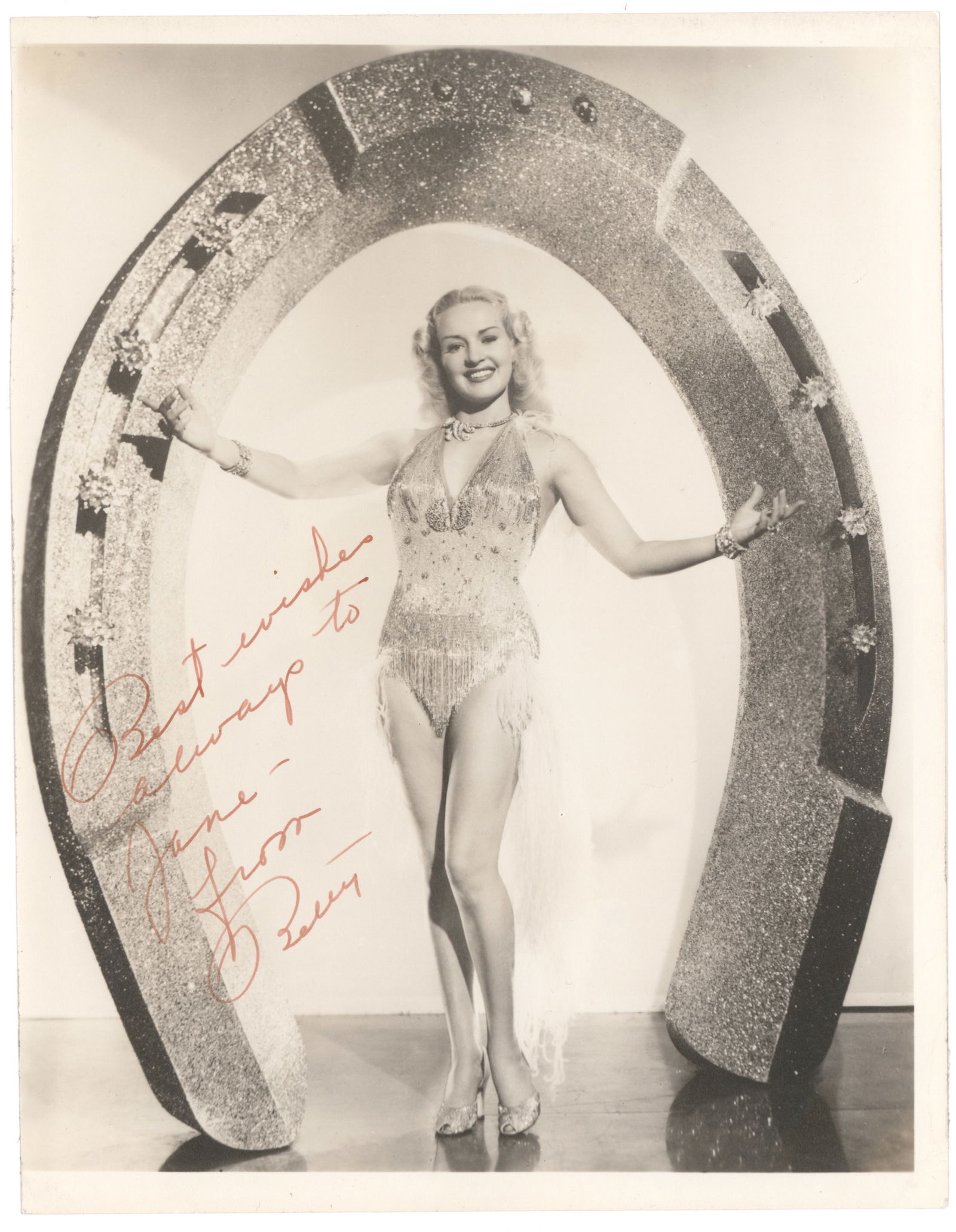 BETTY GRABLE: (1916 - 1973) American actress and pin-up girl of World War II. Superb vintage I.S.P., 7.75 x 9.75 in b/w, an early glamour shot showing Grable full length, inscribed and signed 'Betty' in slightly