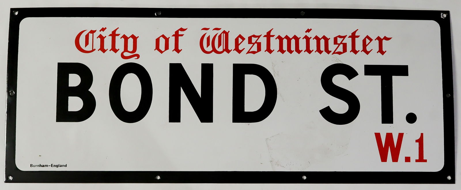 LONDON'S 'BOND ST.' ENAMELED STREET SIGN: A nice decorating piece, an original 30 x 12 in. enameled steel British street sign reading: 'City of Westminster BOND ST. W.1' with maker 'Burnham-England' indicated at bottom. The sign was slightly