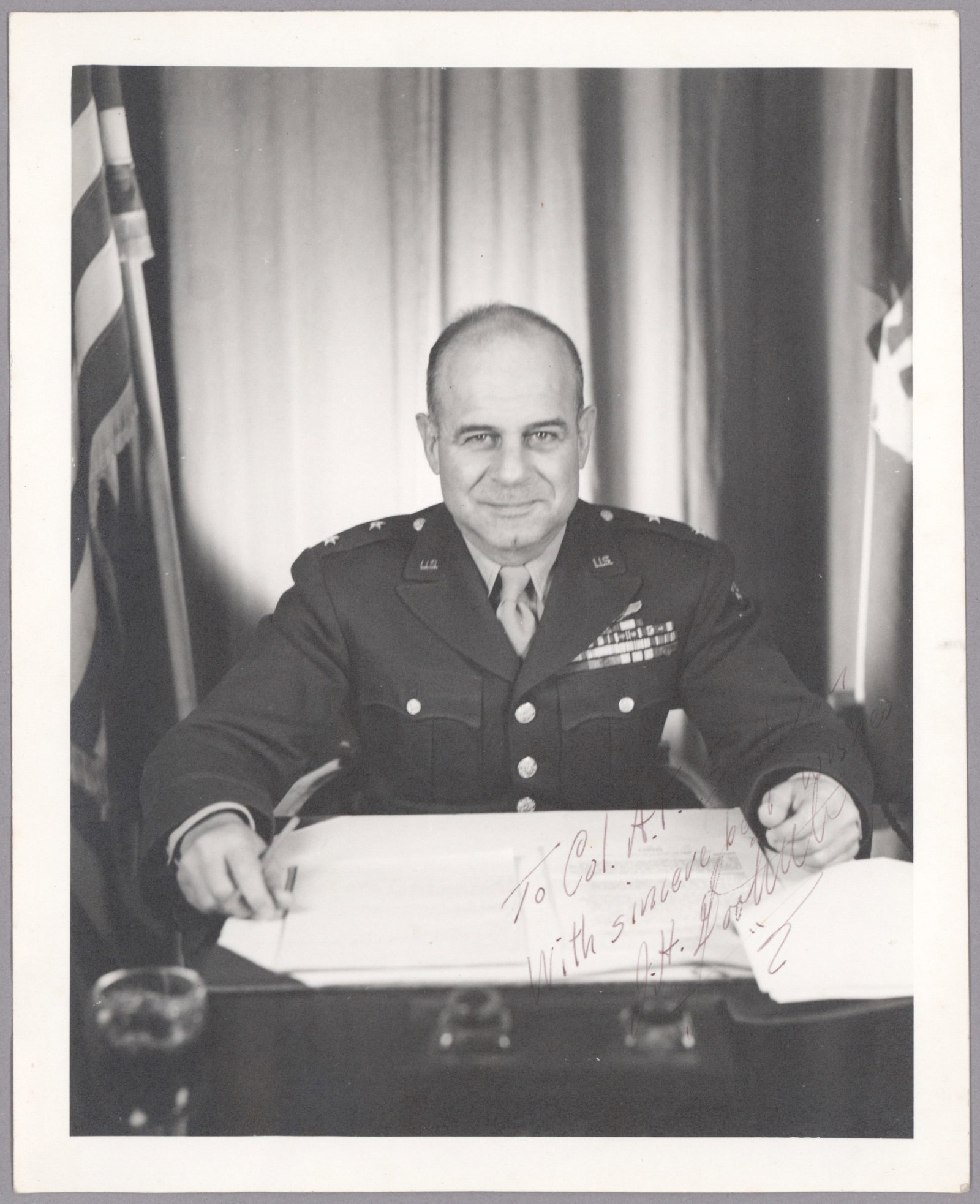 JAMES H. DOOLITTLE: (1896-1993) American aviation pioneer, commander of the Doolittle Raid against Tokyo. Vintage I.S.P. 8 x 10 in. b/w, shows Doolittle at his desk in uniform, inscribed to Col. A. F. Sullivan.