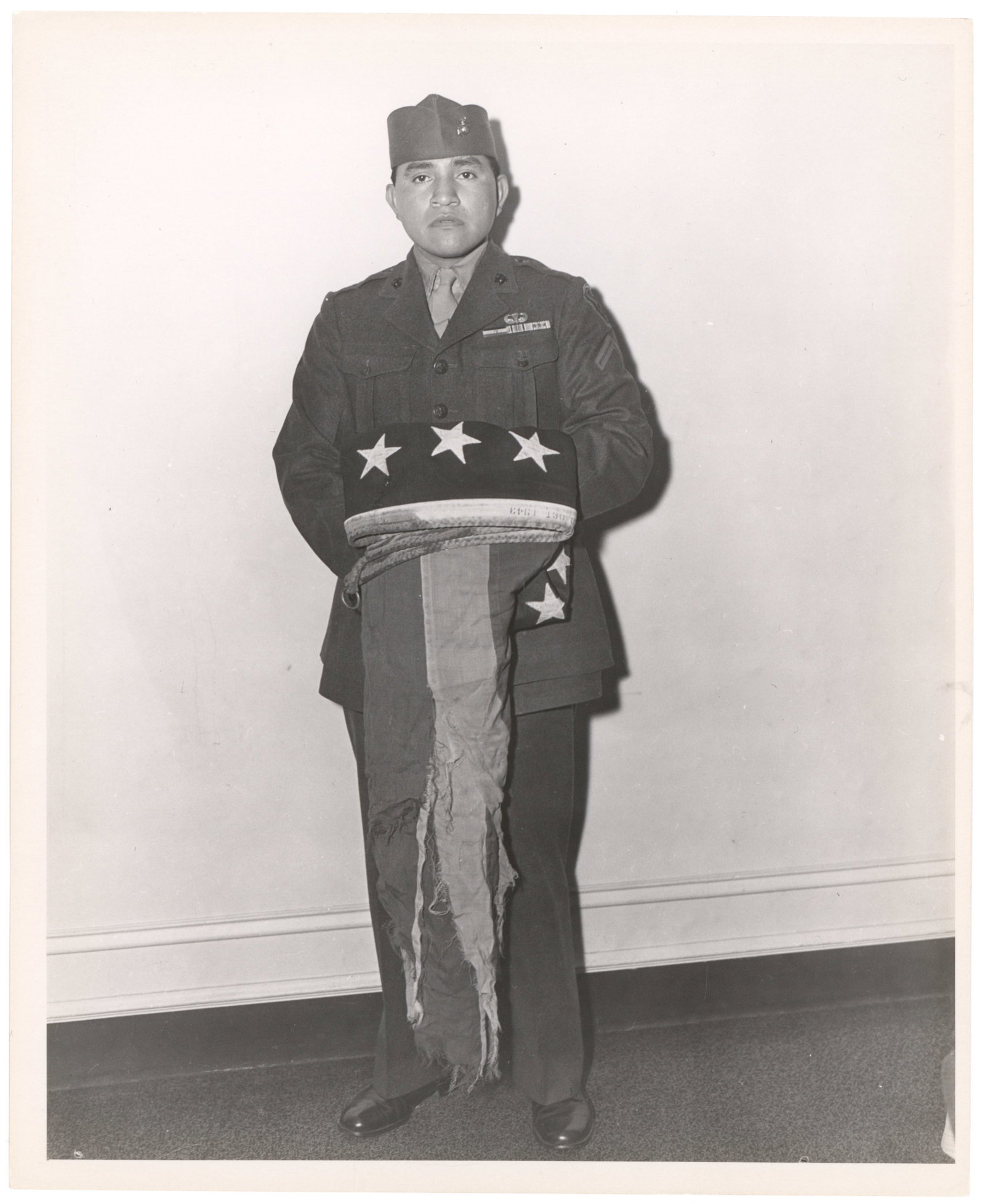 (IWO JIMA) IRA HAYES: Two fine Type 1 photographs showing soldiers who raised the U.S. flag on Mt. Suribachi during the battle of Iwo Jim. The photos, 8 x 10 in. each, show USMC flag raiser IRA HAYES with battered flag in