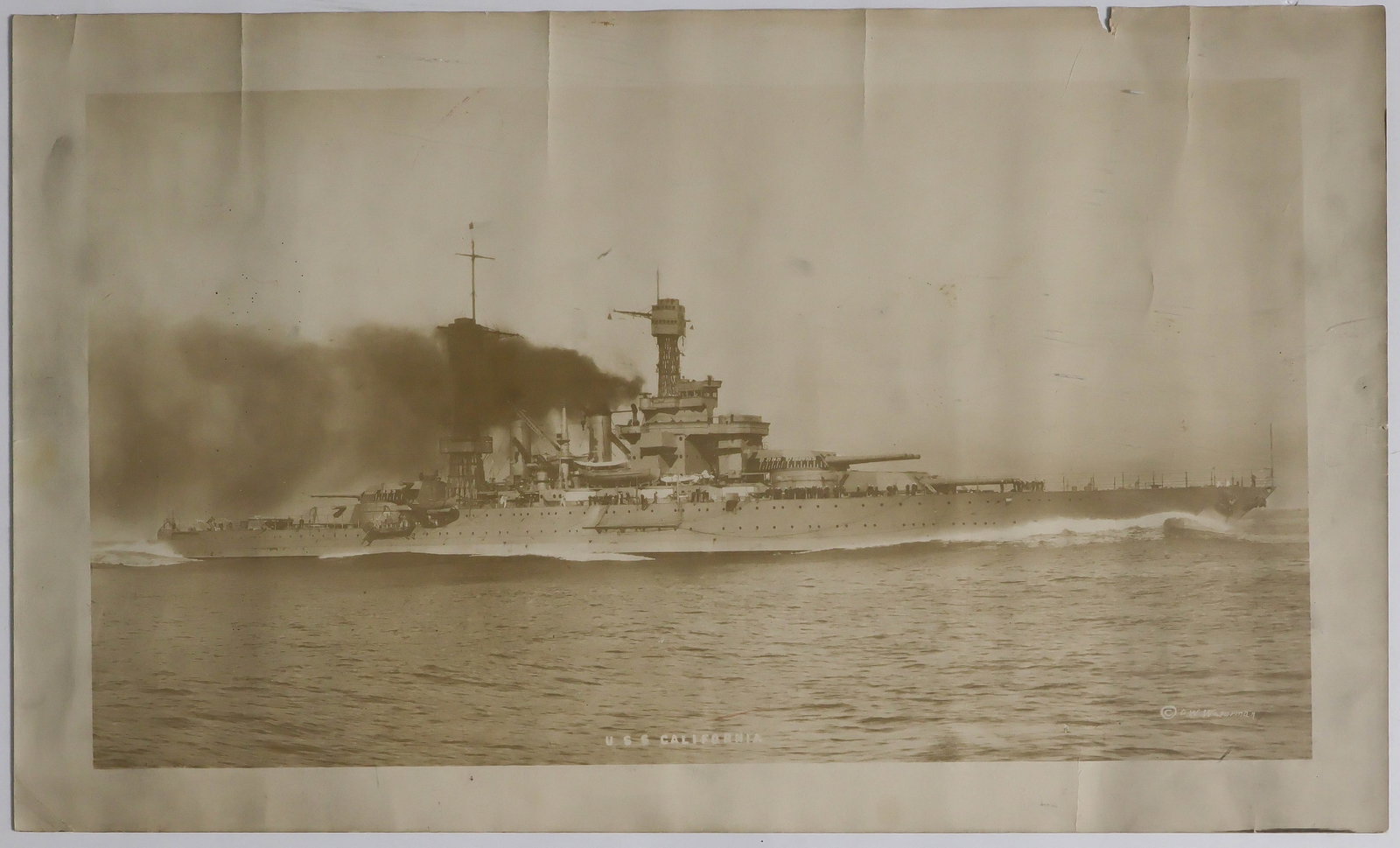 (PEARL HARBOR): A fine period photograph, 20 x 12 in. sepia, an image of the USS CALIFORNIA after being bombed in Pearl Harbor on Dec. 7, 1941. Over the course of the next three days, the CALIFORNIA took on water