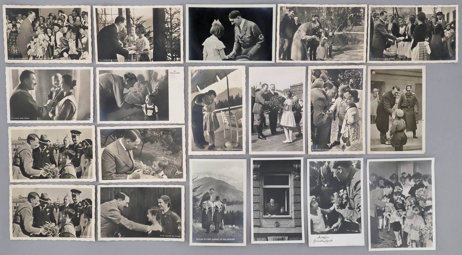 ADOLF HITLER POSTCARDS WITH CHILDREN (19): A group of 19 postcards, each depicting images of the Fuhrer greeting and interacting with children. Includes a most ironic image of Hitler standing and embracing ROSA BERNILE NIENAU (1926–1943)