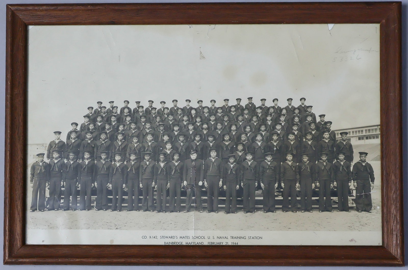 BLACK SAILORS' PHOTOGRAPH, 1944: Scarce photograph of a large group of black sailors, 15 x 9.5 in. (sight), shows six rows of the young sailors in uniform, their white commander shown front and center. The photo is captioned: 'CO.