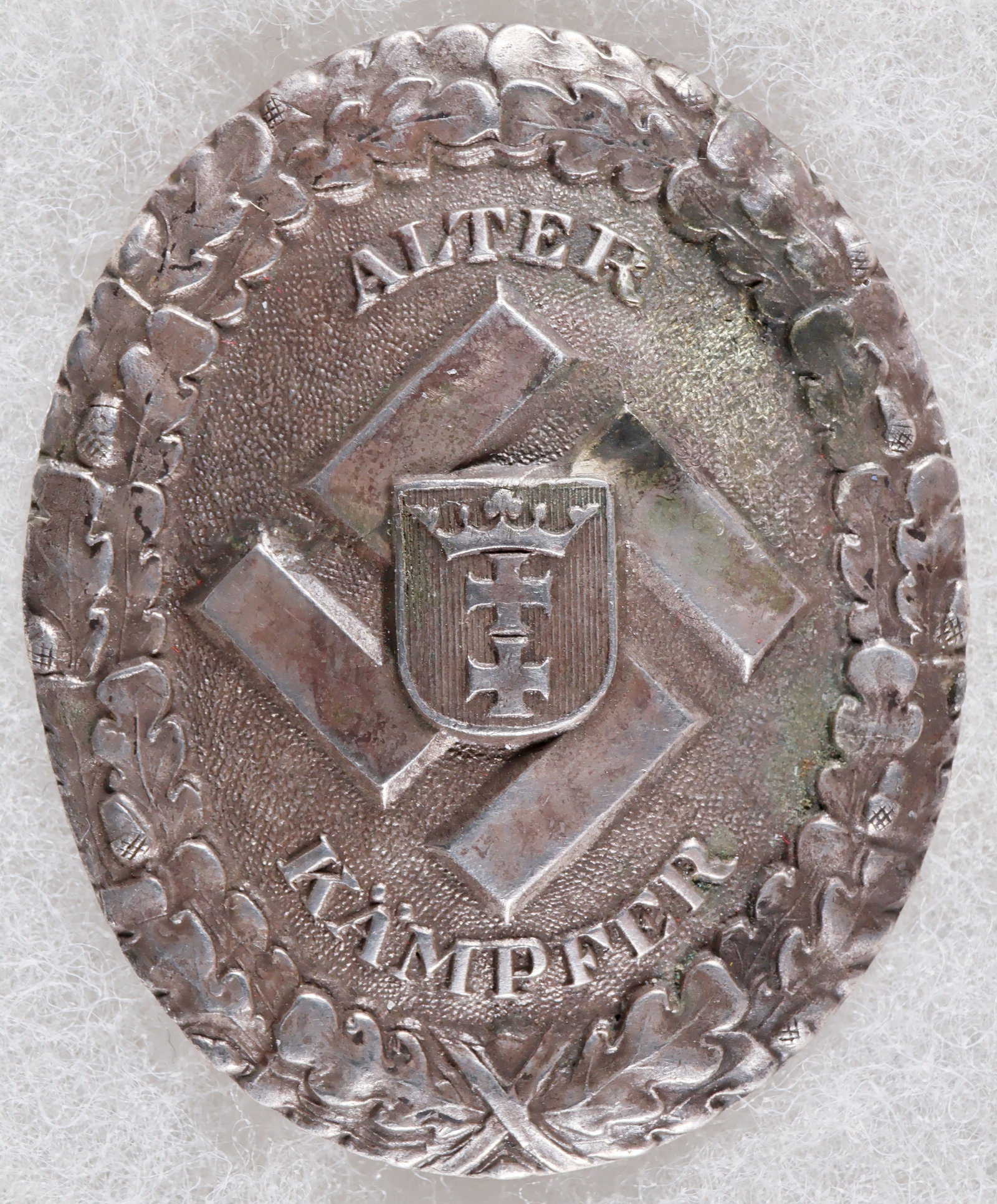 GAU DANZIG ‘OLD FIGHTER’ COMMEMORATIVE BADGE: A rare Third Reich award, a Gau Danzig ‘Alter Kampfer’ (‘Old Fighter’) Commemorative Badge, 1.75 x 1.5 in., of slightly concave silver construction and depicting a mobile swast