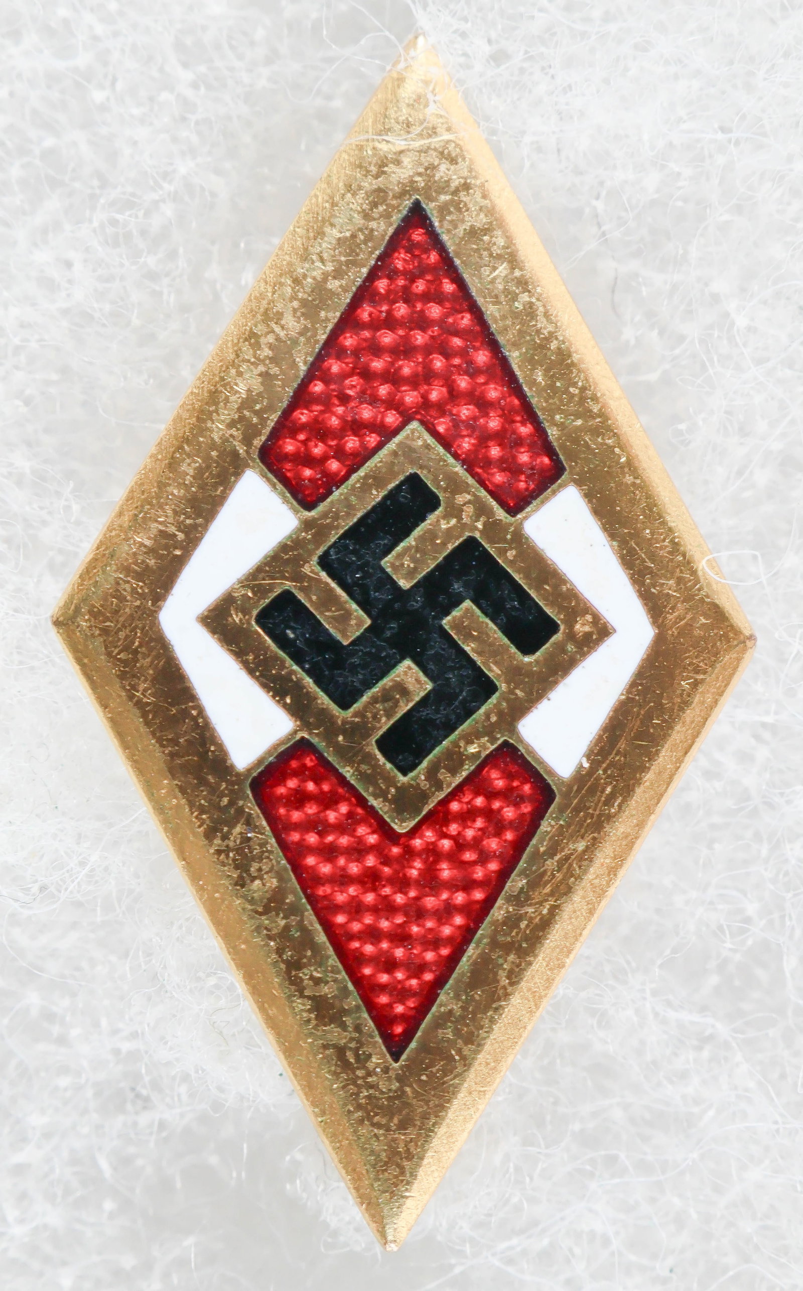 HITLER YOUTH GOLD HONOR BADGE BY PAULMANN & CRONE: Fine example of a Hitler Youth Gold Honor Badge, 1 3/16 in. tall, clean with all enamel intact. The verso bear the issuance number '65664' and is RZM-marked 'M1/78' for maker Paulmann & Crone of