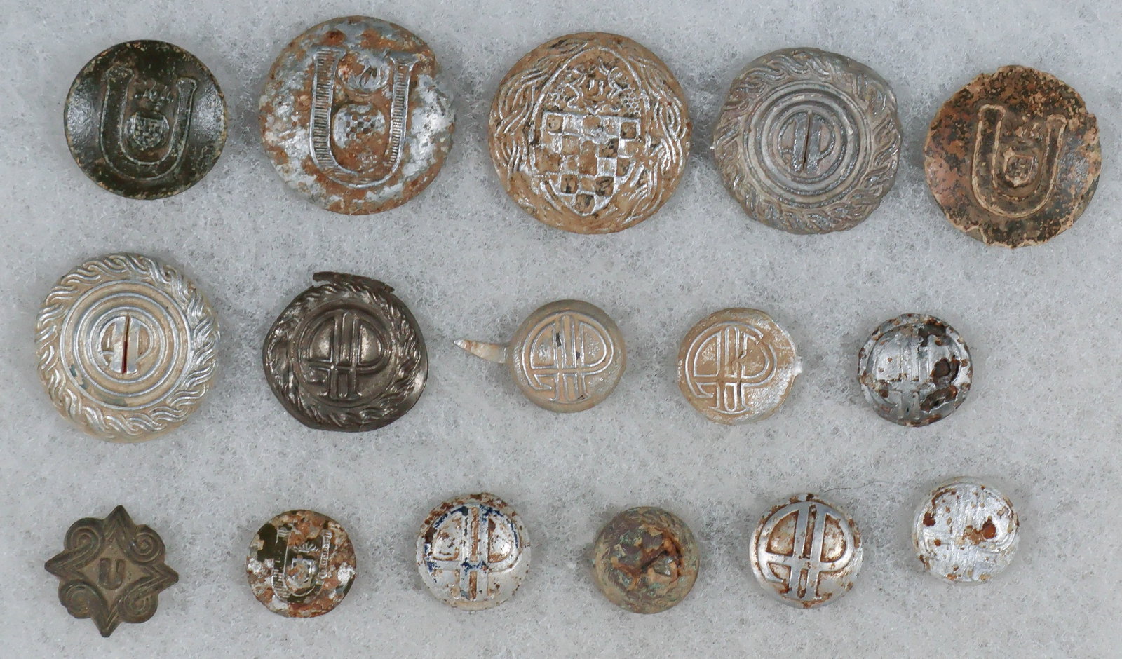 INDEPENDENT STATE OF CROATIA GROUND-DUG BUTTONS (16): A good lot of 16 World War II-era uniform buttons of the Independent State of Croatia, primarily constructed of lead-filled stamped aluminum in a variety of sizes ranging from 0.5 in. to 1 in. dia.
