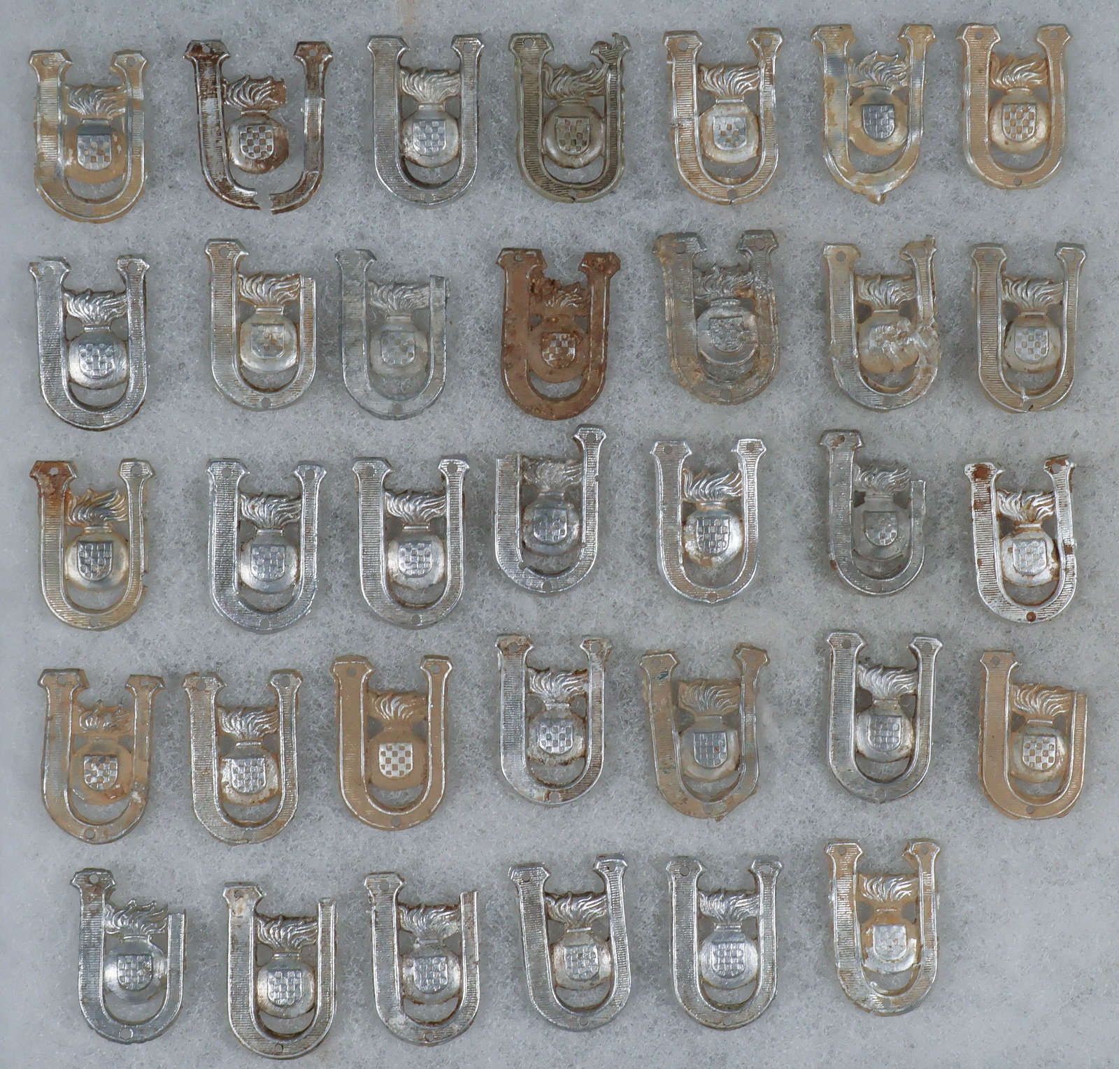 INDEPENDENT STATE OF CROATIA GROUND-DUG USTASE COLLAR INSIGNIA: Large lot of approx. 30 World War II-era stamped aluminum collar badges of the Ustase, the ruling party of the Independent State of Croatia. Each badge measures approx. 0.75 x 1 in., and depicts a