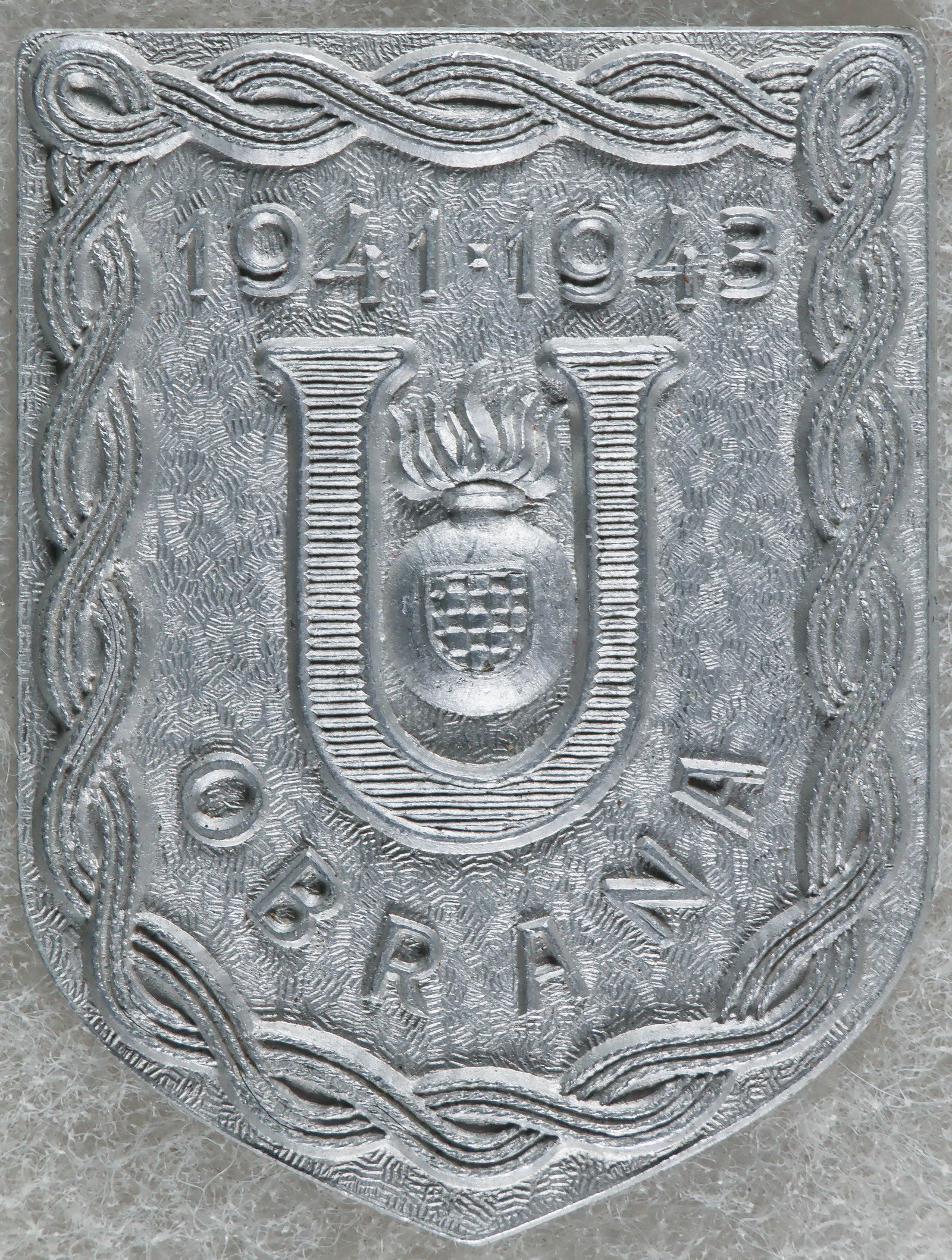 INDEPENDENT STATE OF CROATIA USTASE DEFENSE BADGE: Scarce World War II-era insignia badge, 1.75 x 2.25 in., worn by members of the defense forces of the Ustase, the ruling party of the Independent State of Croatia. The shield-shaped badge is