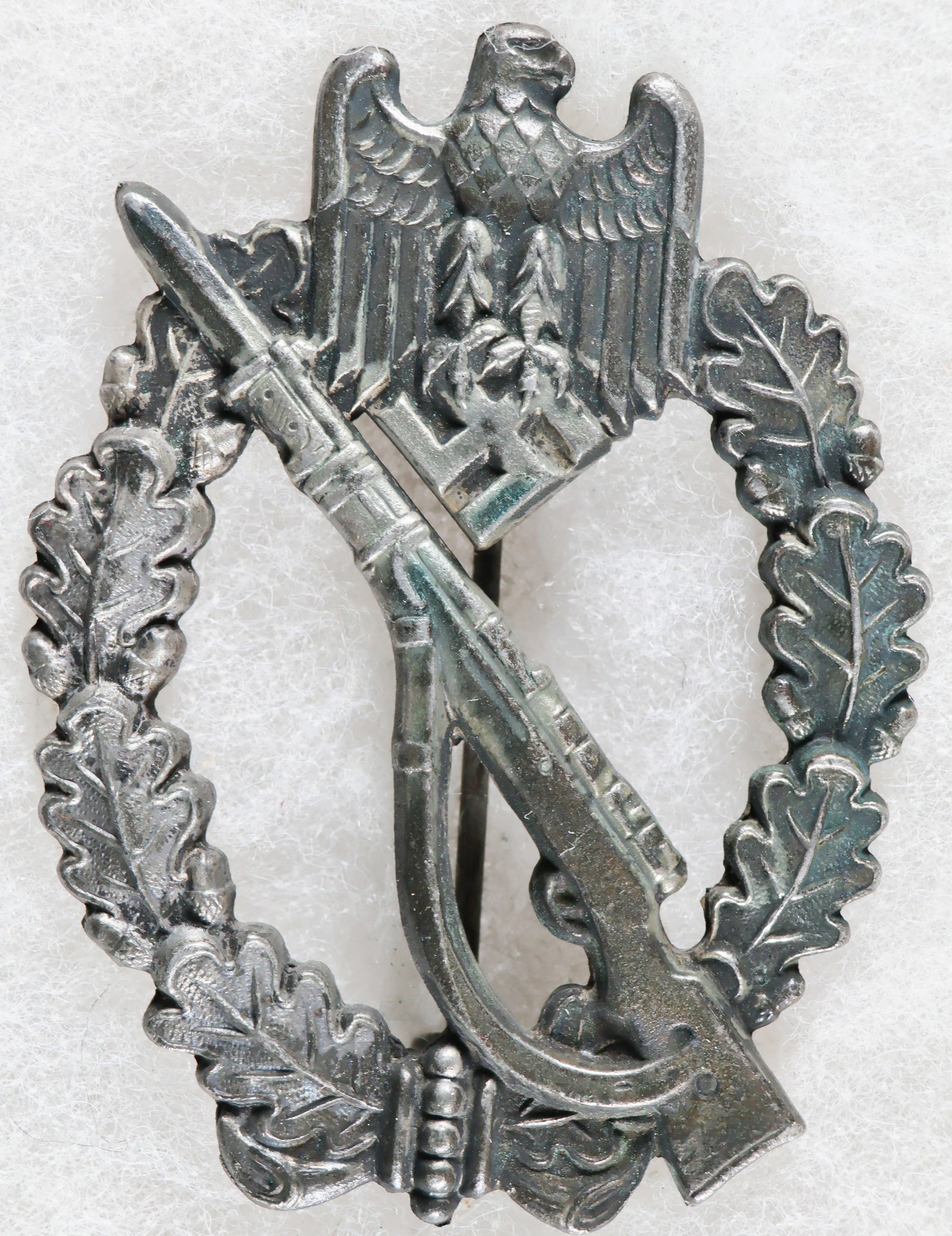 INFANTRY ASSAULT BADGE IN SILVER BY FUNCKE & BRUNINGHAUS: A Wehrmacht ‘Infanterie Sturmabzeichen’, or Infantry Assault Badge, Silver Grade, approx. 1.75 x 2.5 in., of solid, die-stamped zinc construction with a silver wash finish to the obverse