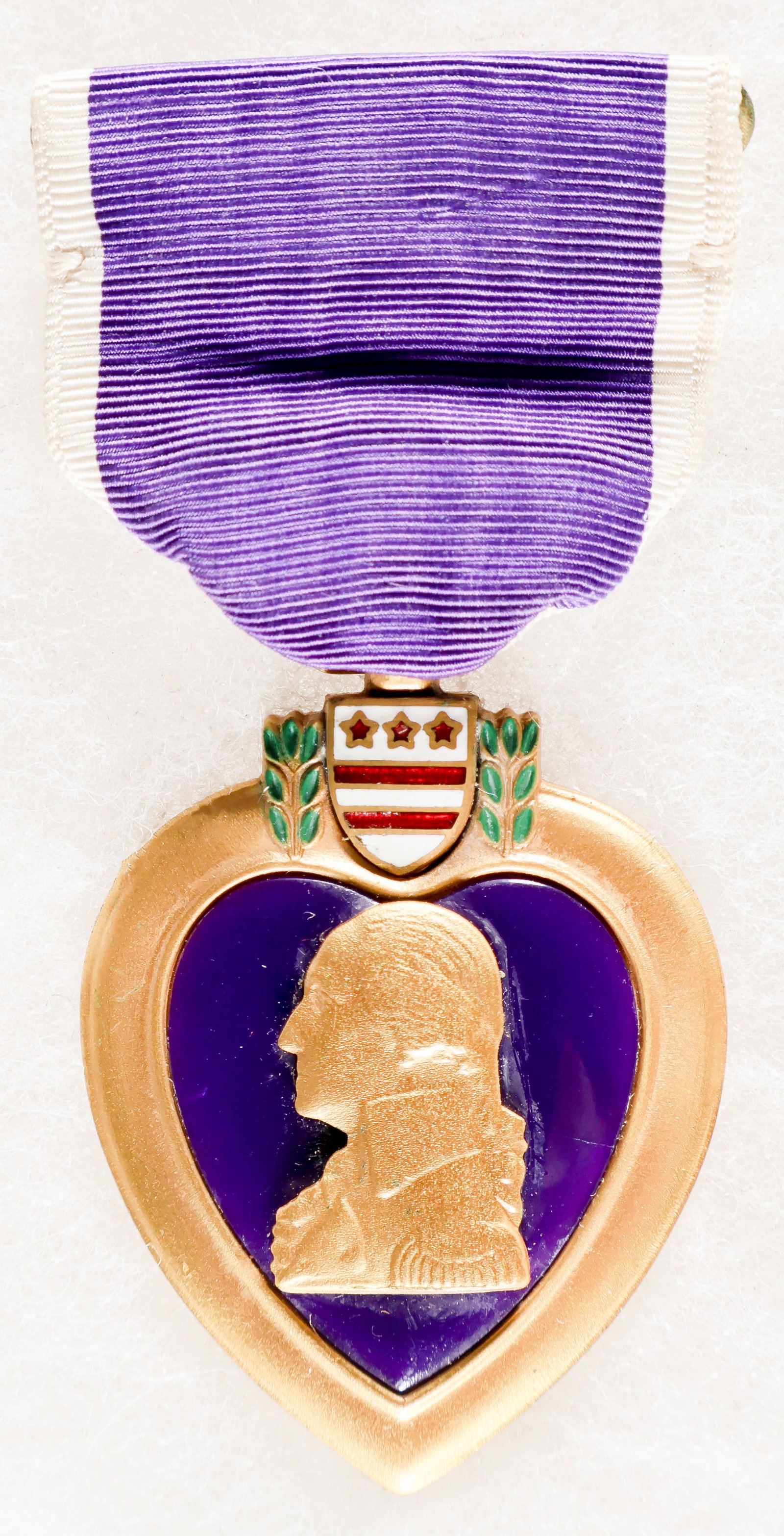 NAMED AND CASED PURPLE HEART MEDAL: A Purple Heart medal with slot-bar suspension, engraved on the reverse as being awarded to a Cleveland G. Thompson. The medal is housed in its original presentation case, and shows very slight