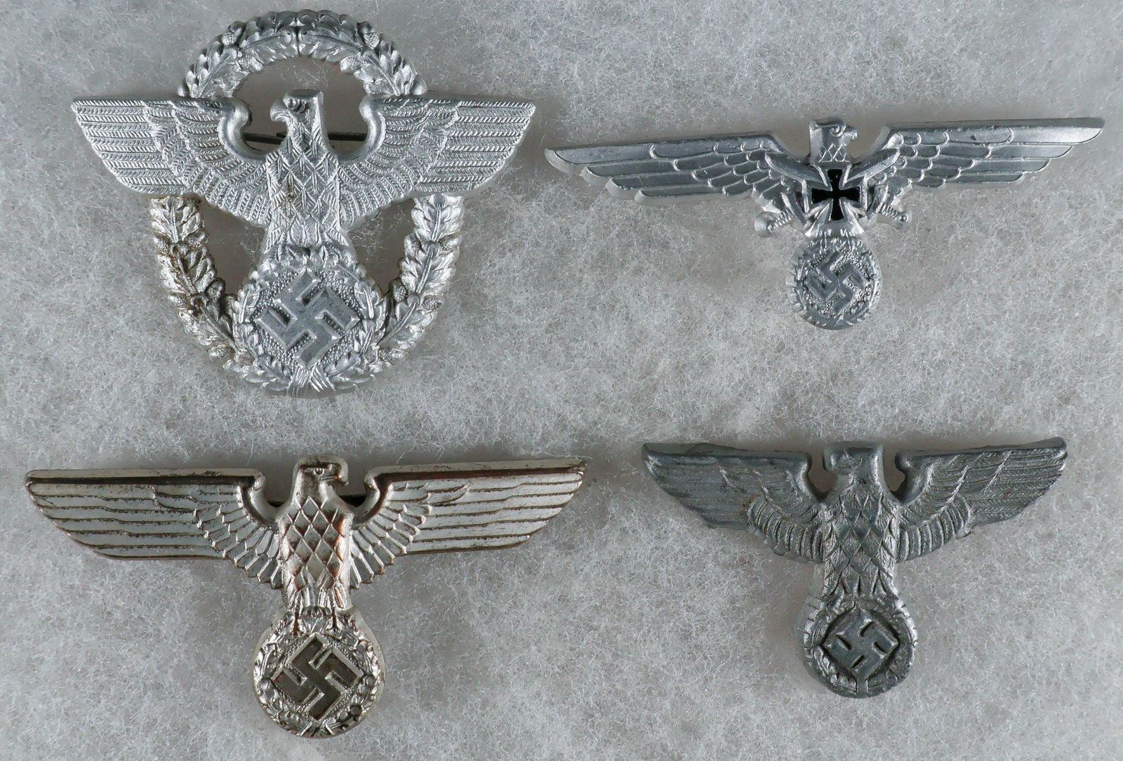 NSDAP, POLIZEI AND KYFFHAUSERBUND CAP BADGES (4): Good lot of four Third Reich cap badges, includes left- and right-facing NSDAP eagles, one with pinback clasp, as well as an aluminum Polizei emblem, maker-marked ‘JFS’ on the reverse, and
