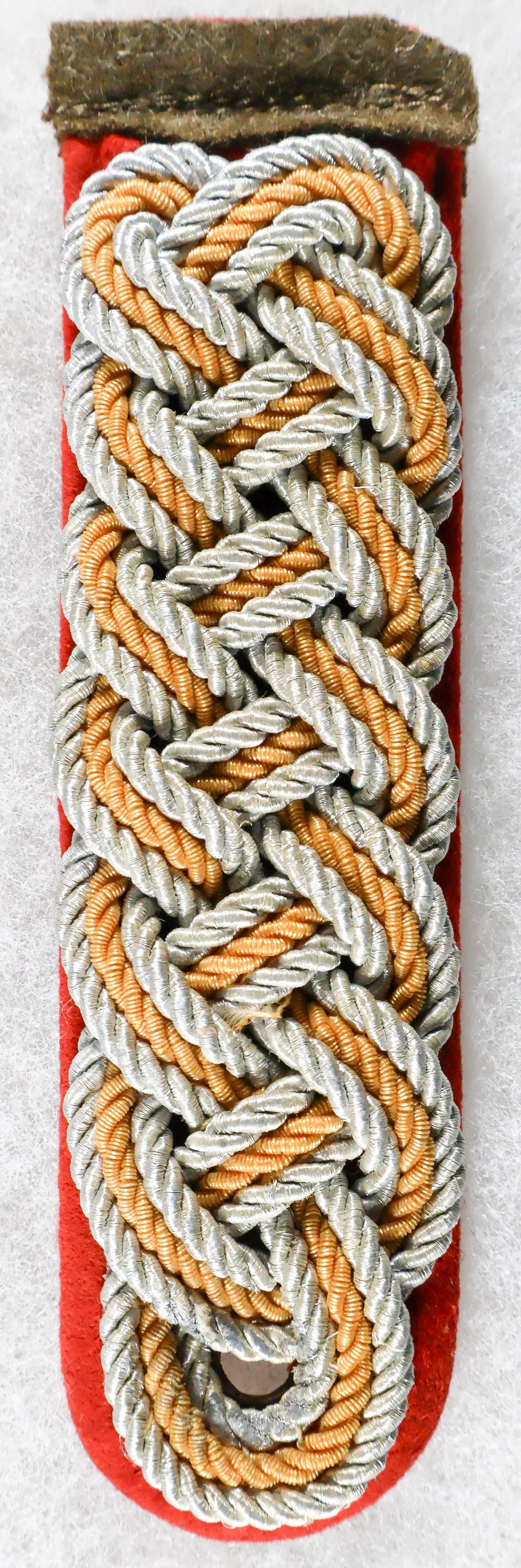 S.A. GENERAL OFFICER’S SHOULDER BOARD: A Third Reich shoulder board, approx. 4.75 x 1.25 in., worn by general officers of the Sturmabteiling (SA) from grades Oberfuhrer through Obergruppenfuhrer. The board is constructed of red wool with