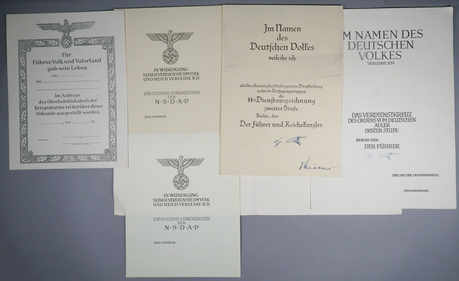 WORLD WAR II AWARDS DOCUMENTS: Four blank ‘Urkunde’ award documents: the first the SS Long Service Decoration, Second Class, 1p. legal folio, signed in type by Hitler and Otto Meissner. Exhibits soiling, else very