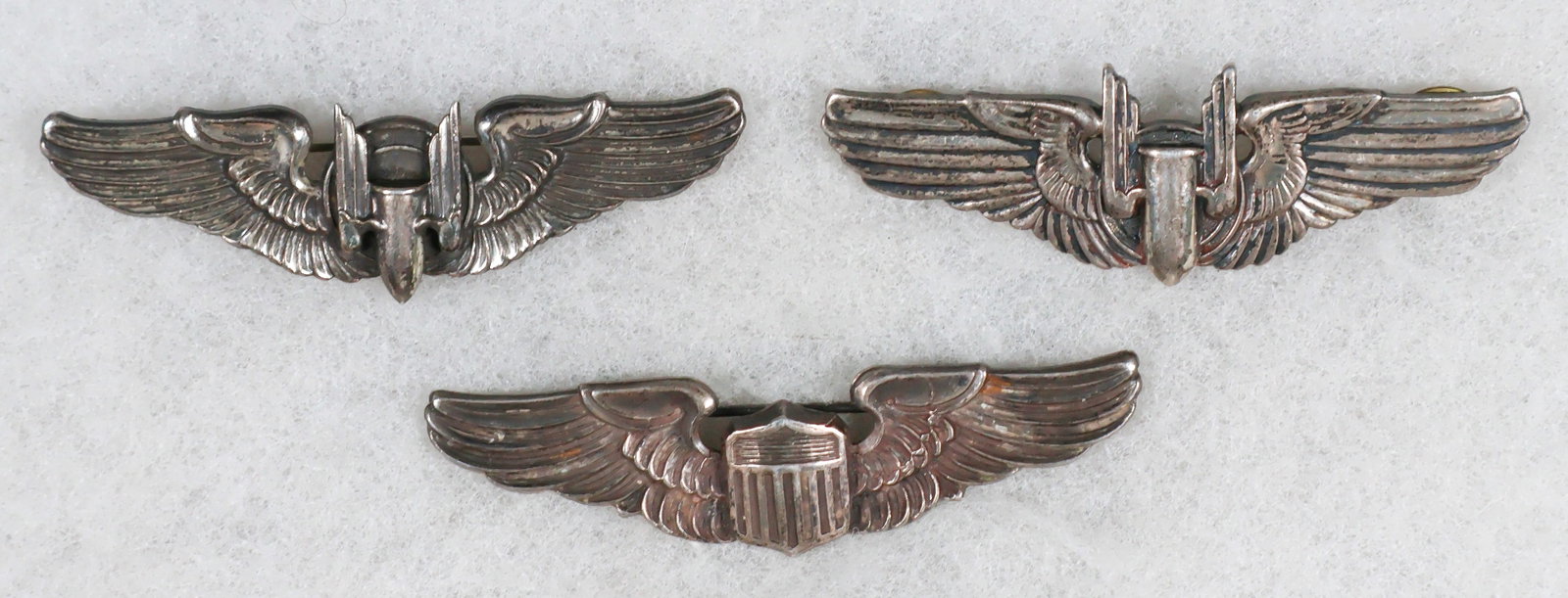WORLD WAR U.S. WINGS GROUP (3): Three original World War II aviator’s wings: USAAF pilot’s wings, 3 in. wide, hallmarked ‘Sterling’ on reverse below a maker’s mark for Meyer, Inc. of New York. Pin