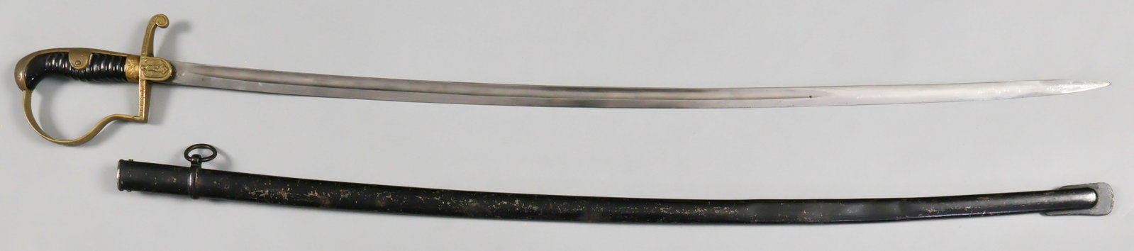 WORLD WAR II GERMAN OFFICER’S SWORD: World War II WKC Model Nr 1055 German officer's sword with a slightly curved blade, 32.5 in. long, 38 in. overall, gilt brass langet in form of Nazi eagle with down-spread wings and swastika, engraved