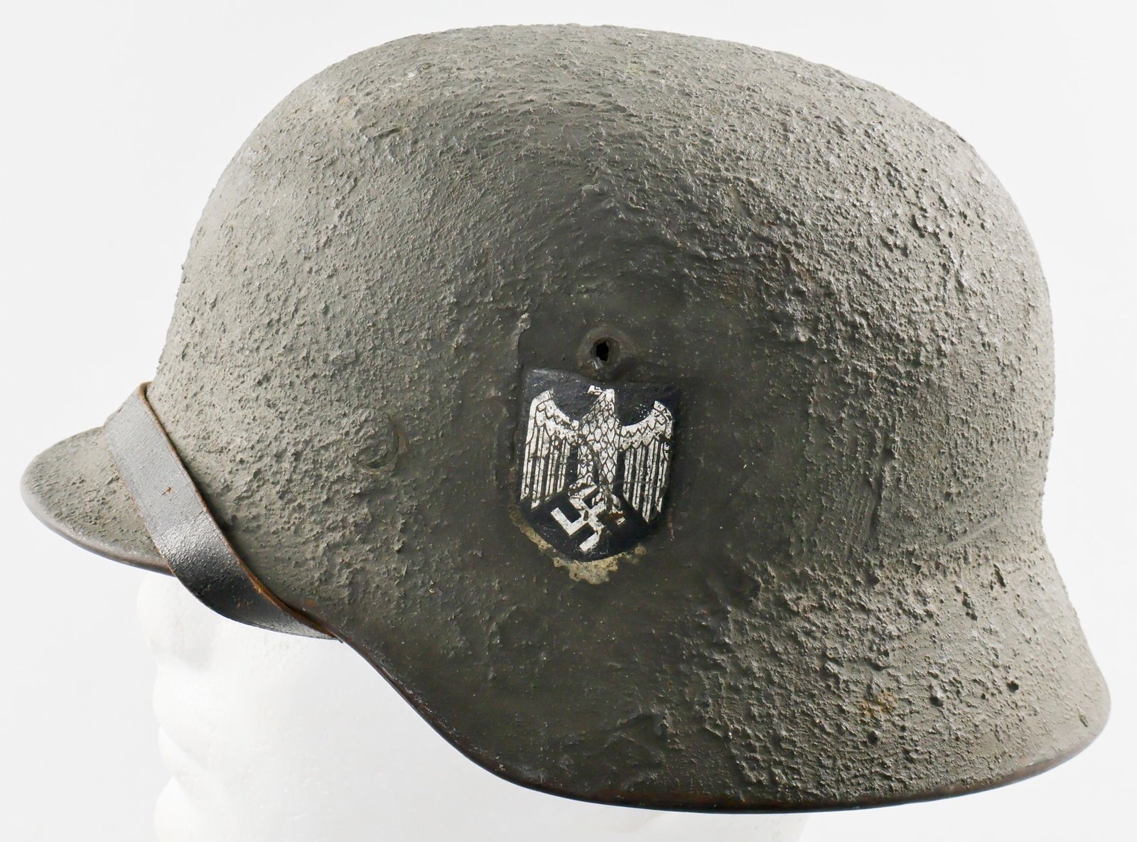 M35 HELMET WITH HEAVY CAMOUFLAGED FINISH: German M35 single decal Heer (Army) helmet with a rare, hand-applied heavy textured camouflage finish. The finish was neatly applied so as not to obscure the Wehrmacht eagle decal on the left side, an