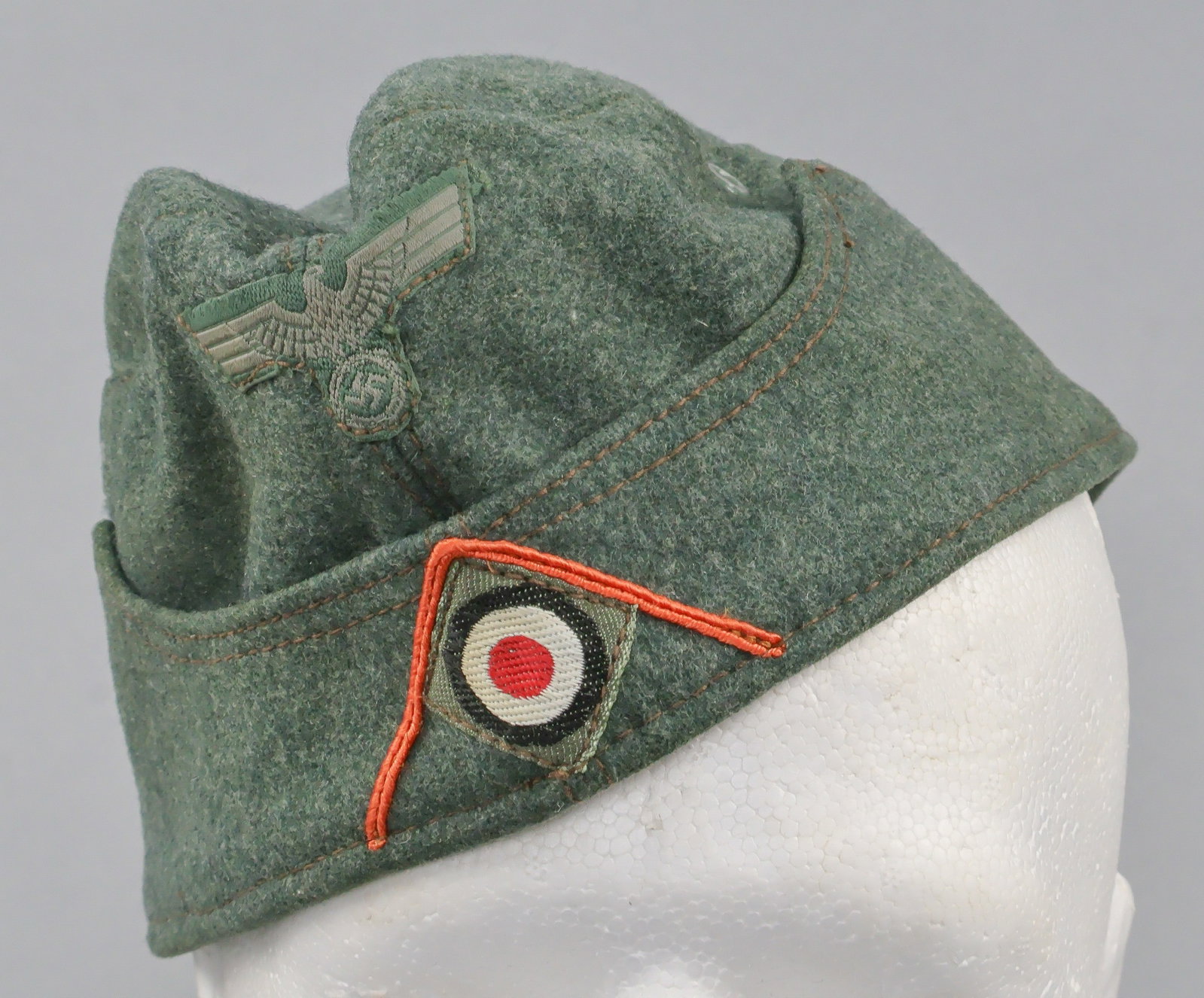 WEHRMACHT FELDGENDARMERIE OR RECRUITER’S OVERSEAS CAP: A rare Heer M34 overseas or garrison cap, constructed of field-gray wool with a seam running from the rear edge, over the crown and down the front, and with two flaps sewn to each side at the rim. A m