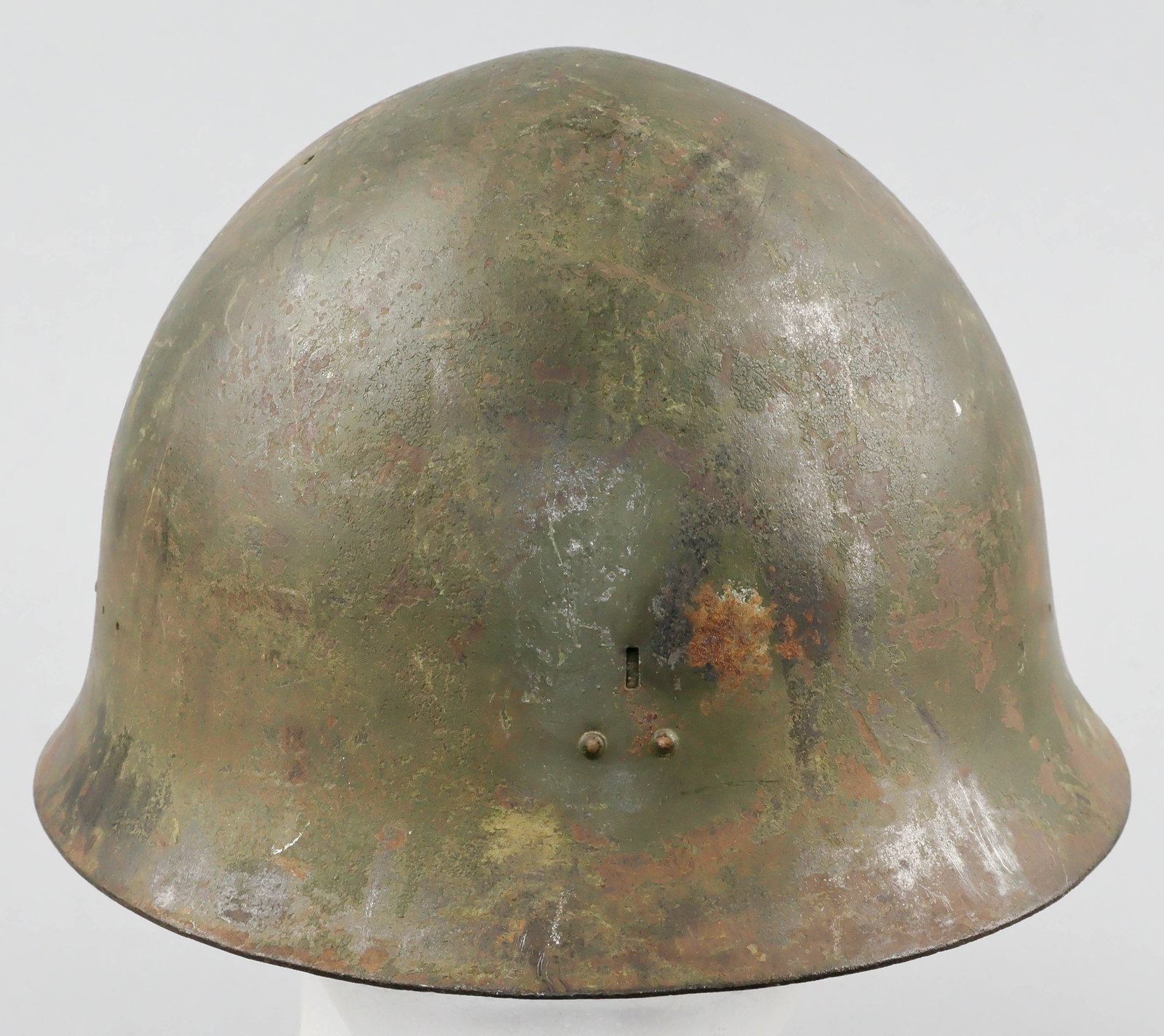 JAPANESE TYPE 90 CIVIL DEFENSE HELMET SHELL: An Imperial Japanese Army Type 90 steel helmet, finished overall with greenish-brown paint. The rear interior skirt of the helmet is stamped with a kanji denoting the size ‘large’, beneath