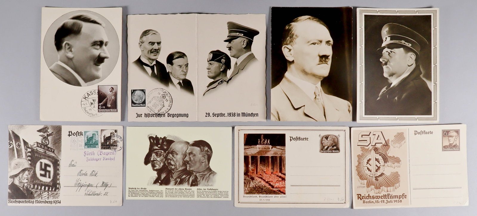 THIRD REICH POSTCARDS (7): A group of six Hostcards with images of Hitler, Hitler and Mussolini, the 1938 SA rally, 1934 Nuremberg Rally, and more. Two are postally used. Also includes a 4 in. x 6 in. sepia head and shoulders p