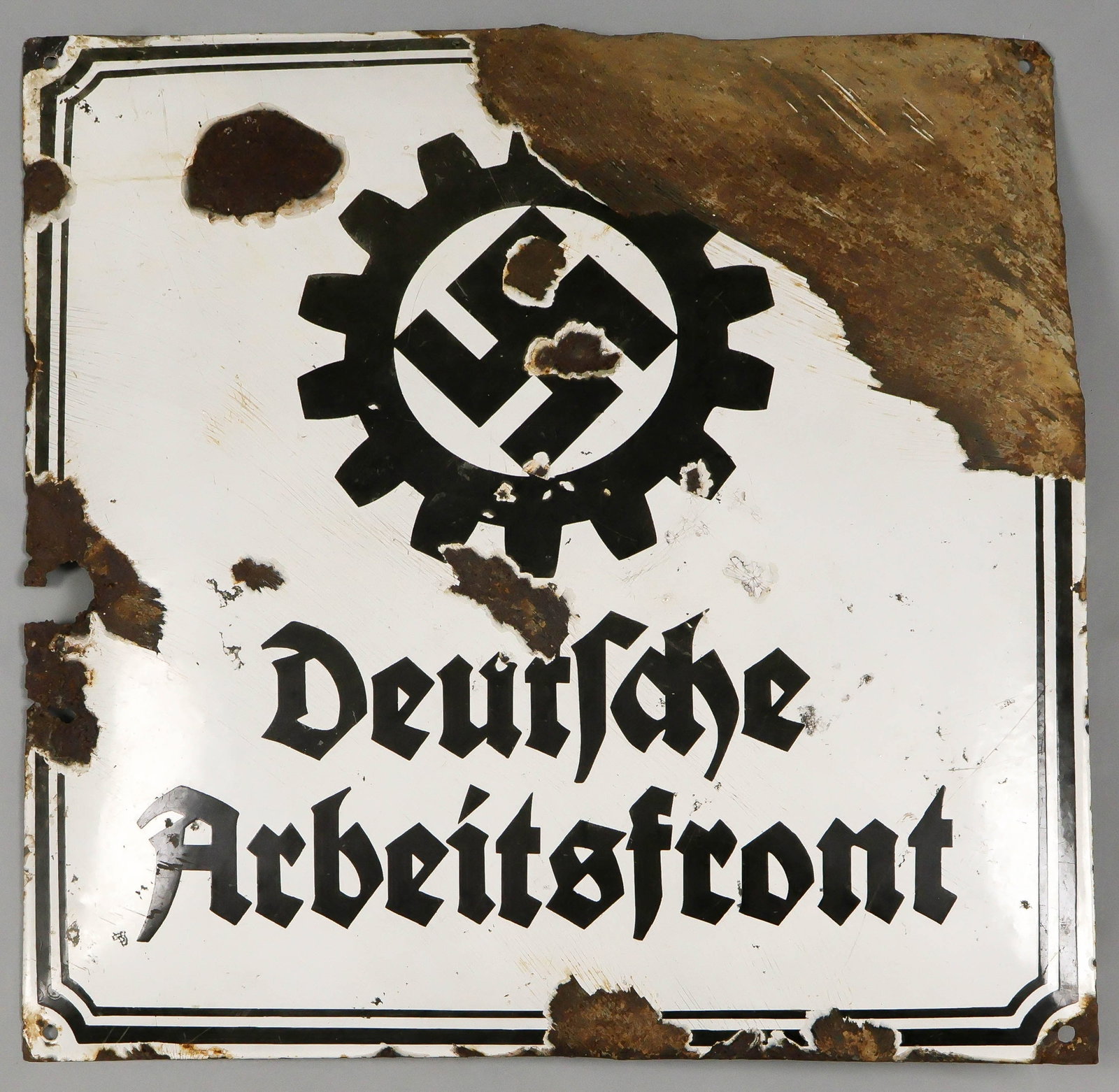 'DEUTSCHE ARBEITSFRONT' ENAMEL SIGN: Uncommon, large 'Deutsche Arbeitsfront' enameled steel sign with the organization's emblem at center, 19.75 in. square, outwards. Heavily damaged in places, unquestionably authentic. The Deutsche