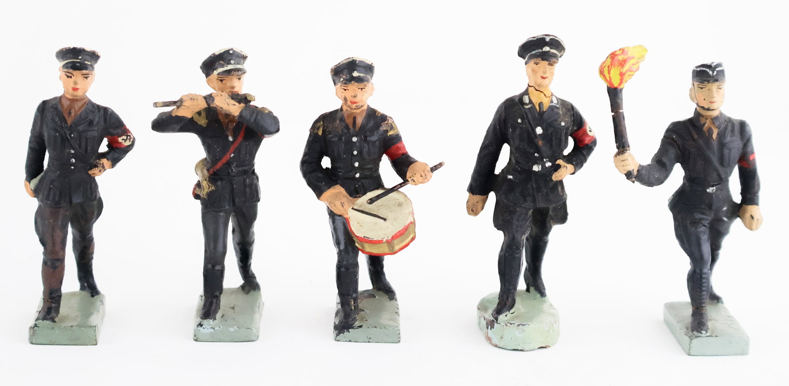 'ELASTOLIN' SS SOLDIERS ON PARADE (5): Good lot of five 'Elastolin' toy soldiers, each about 3.25 in. tall, all dressed in black SS uniforms and clearly part of a parade. Included is a man playing a fife, a drummer, a torch-bearer, and two