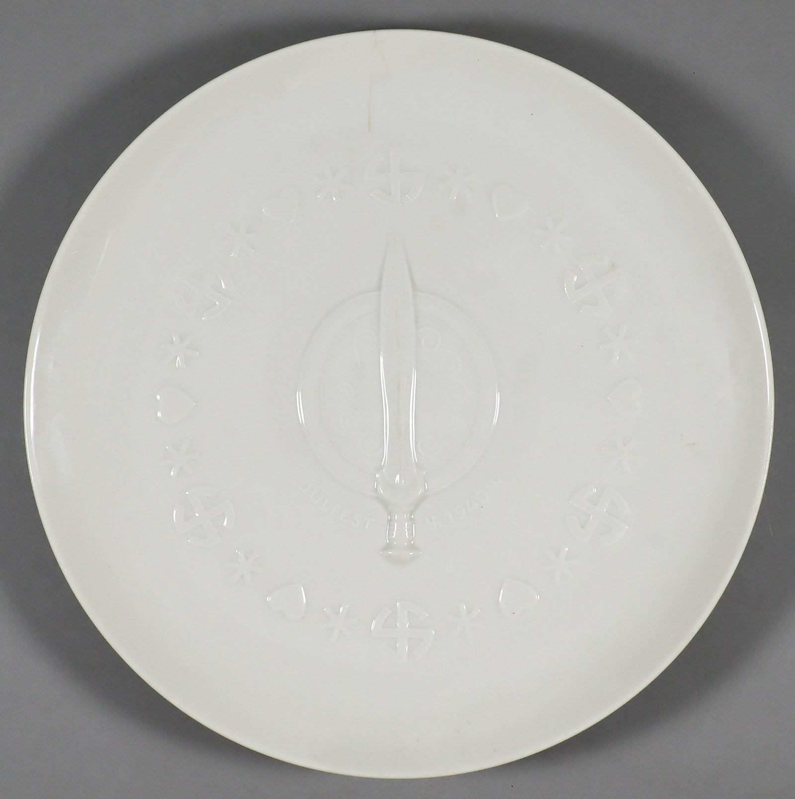 ALLACH 1940 PRESENTATION YULFEST PLATE: Scarce Allach 1940 presentation Yulfest plate no. #528, a gift plate made of white porcelain with relief lettering 'Julfest 1940' with various runes and pinwheel swastikas, an upraised sword at