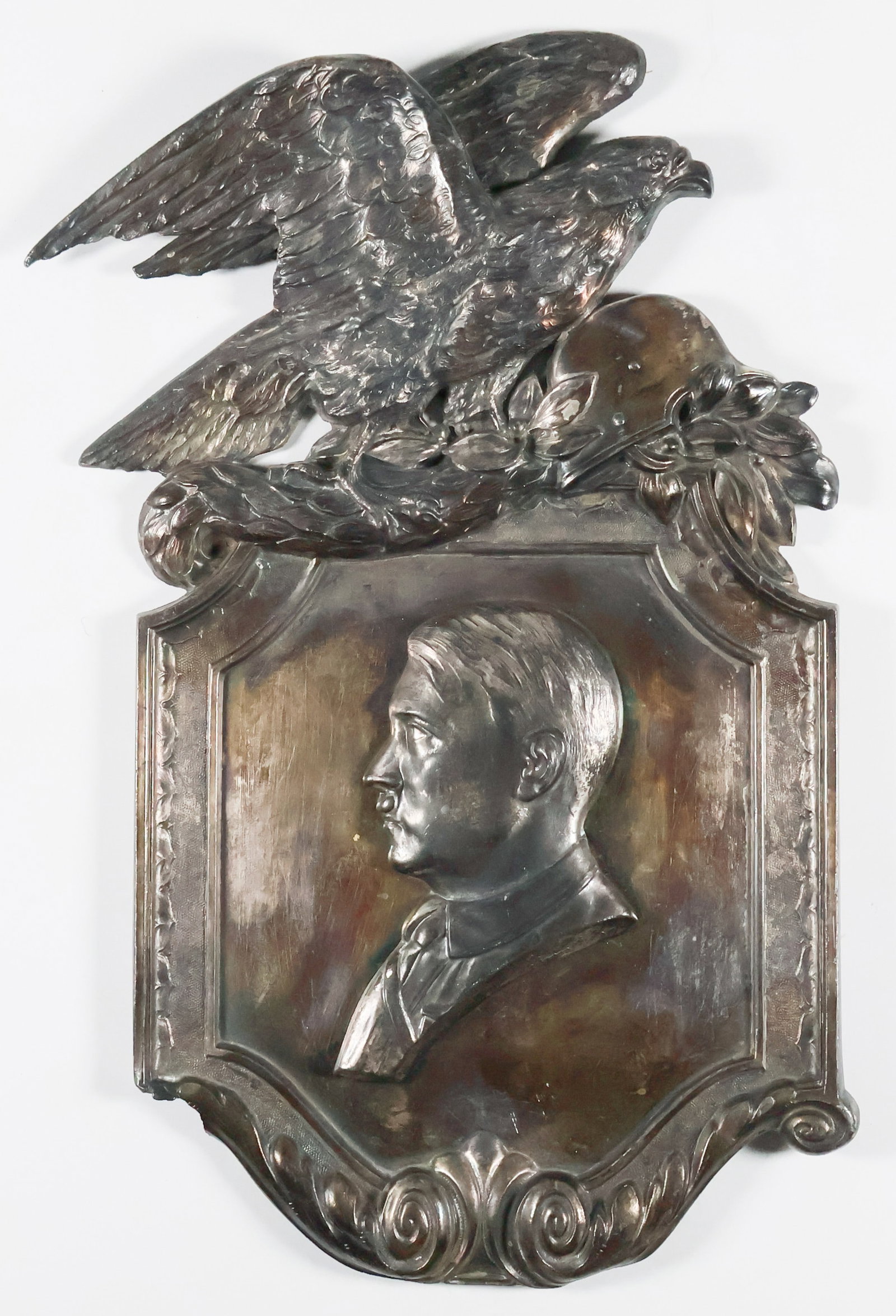 ADOLF HITLER PATRIOTIC PLAQUE: Silver toned plaque, 8 in. x 12.25 in., displaying an Adolf Hitler bust of left profile in relief, bust emblem showing an artist’s signature, ‘Schmidt-Hofer’ underneath his shoulder,